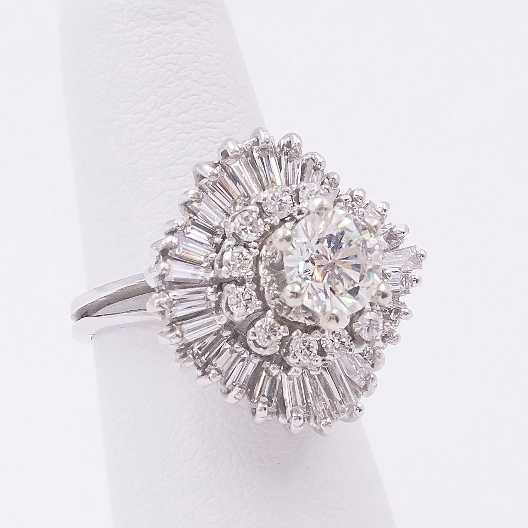 A large and impressive Diamond Ballerina style ring is centred with one round, Brilliant Cut 1.05 carat Diamond inside a Surround of twelve Round Brilliant cut smaller stones and surrounded with waves of 28 fancy Baguette Cut  Diamonds. The total