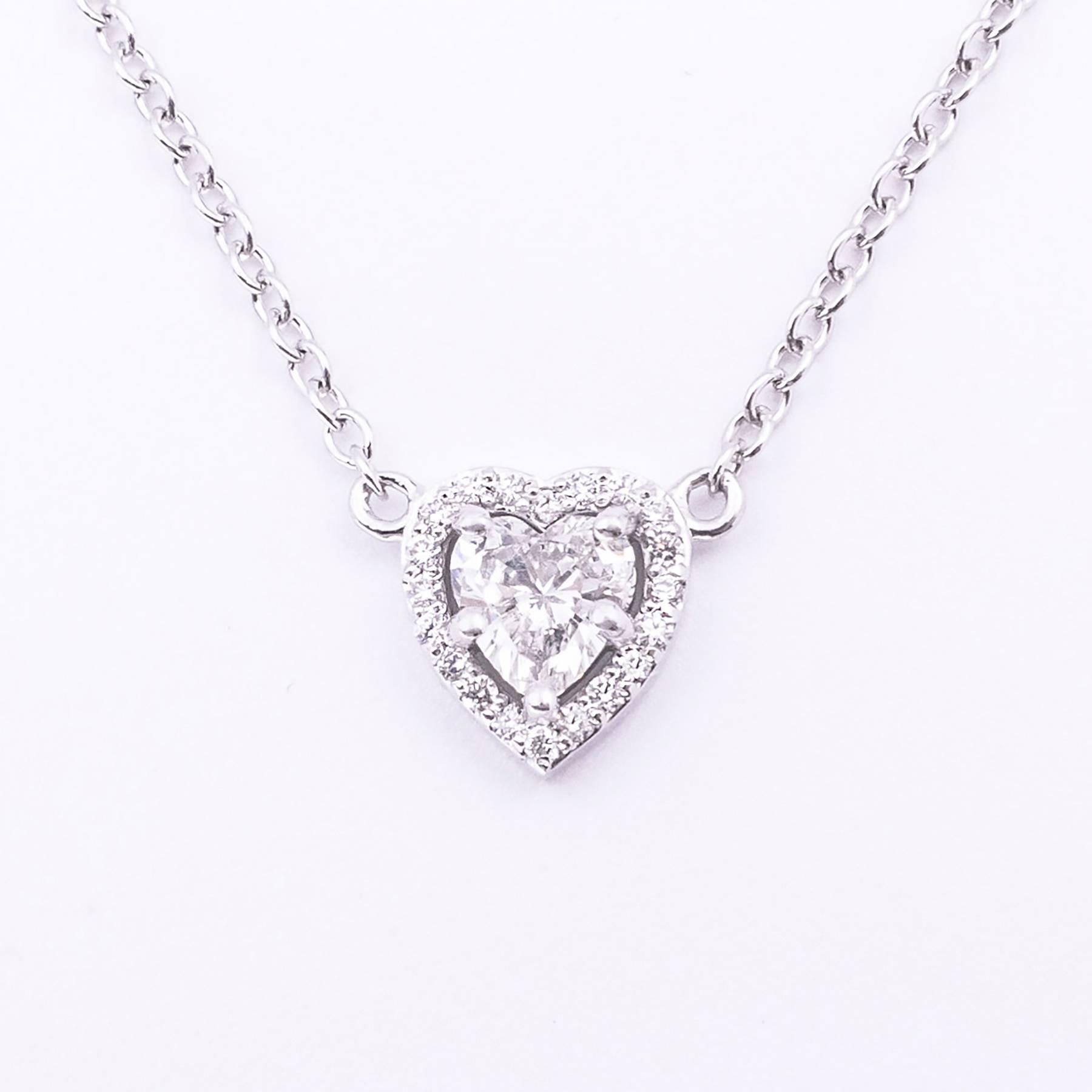 A half carat (.50) fancy cut Brilliant Heart Shaped Diamond is custom set in 18 karat white gold and surrounded with 20 Round Brilliant Cut Diamonds in this beautiful pendant totaling .67 carats.

The pendant hangs lavaliere style from an 18 karat,