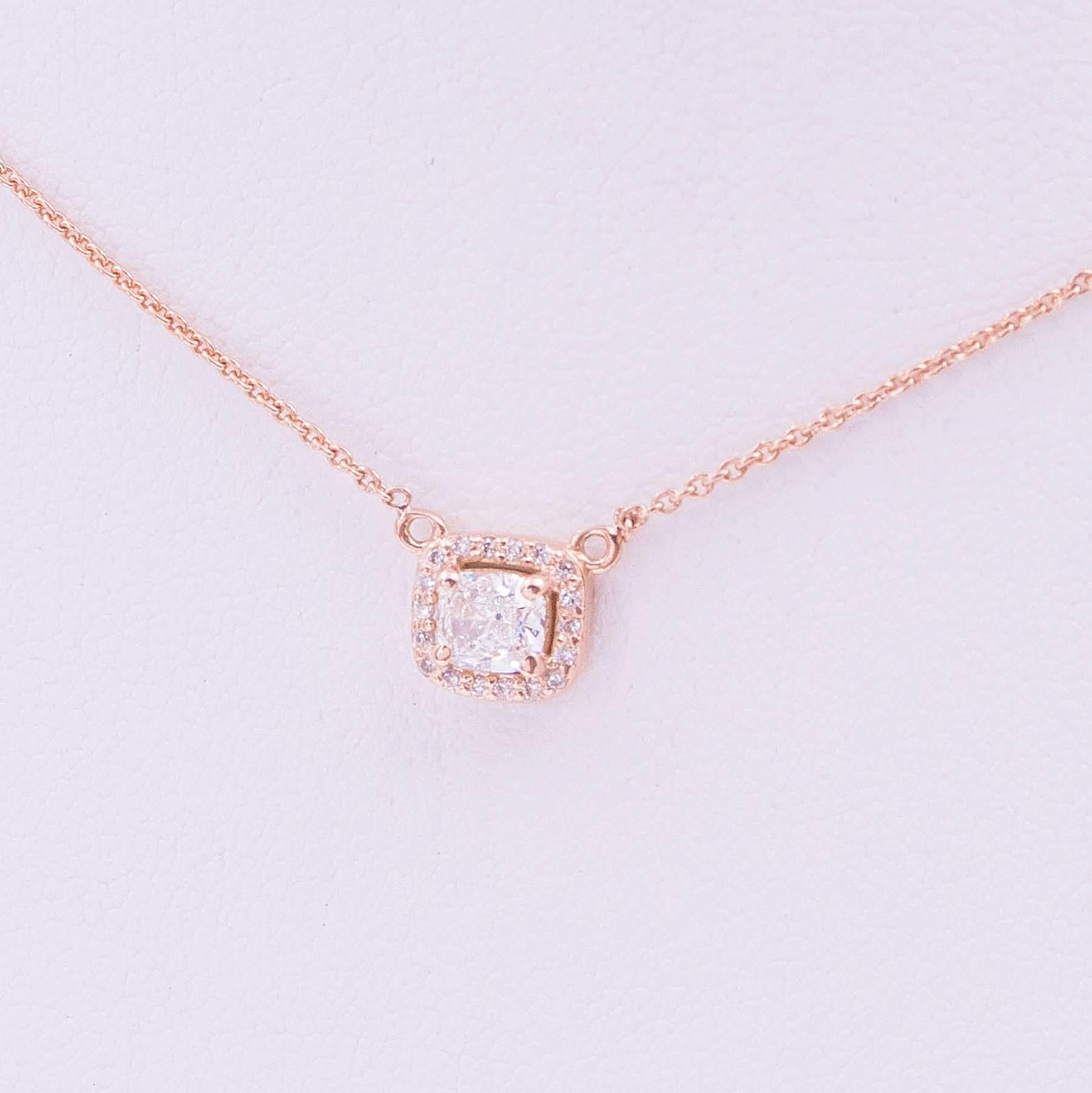 A fine Cushion Cut F Color, VS2 Diamond is hand crafted in 18 karat Rose Gold set with 4 prongs and surrounded by 18, E-F-G, VS Round, Brilliant Cut and bead set Diamonds. The finished pendant measures approximately 10.5mm and hangs lavaliere style