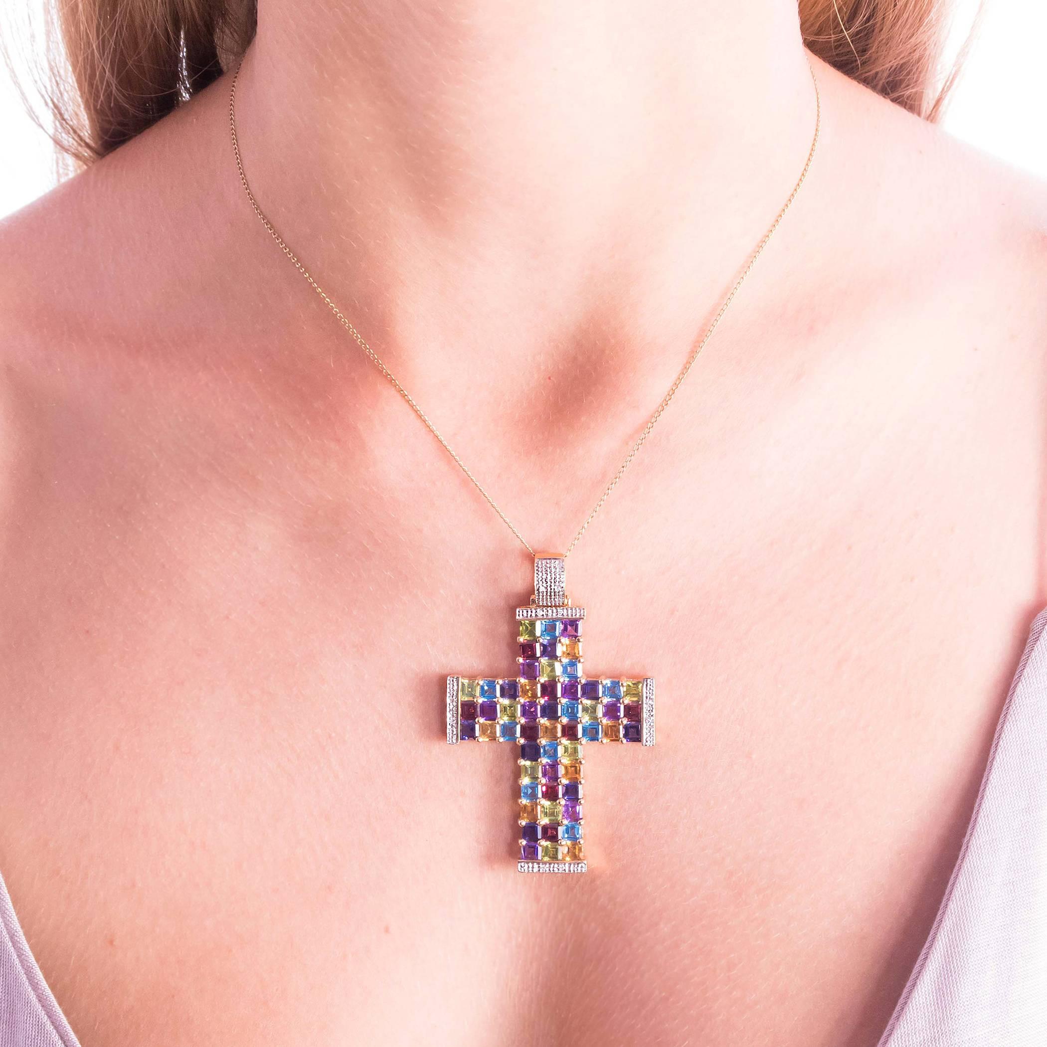 An outstanding Diamond and Multicolor Gemstone Gold Cross Pendant. Set in 14 karat yellow gold is shared claw set with 54 square, 10mm step cut colored gemstones and 10 small, bead set Diamonds in the moveable bale and ends of the Cross.

Colored