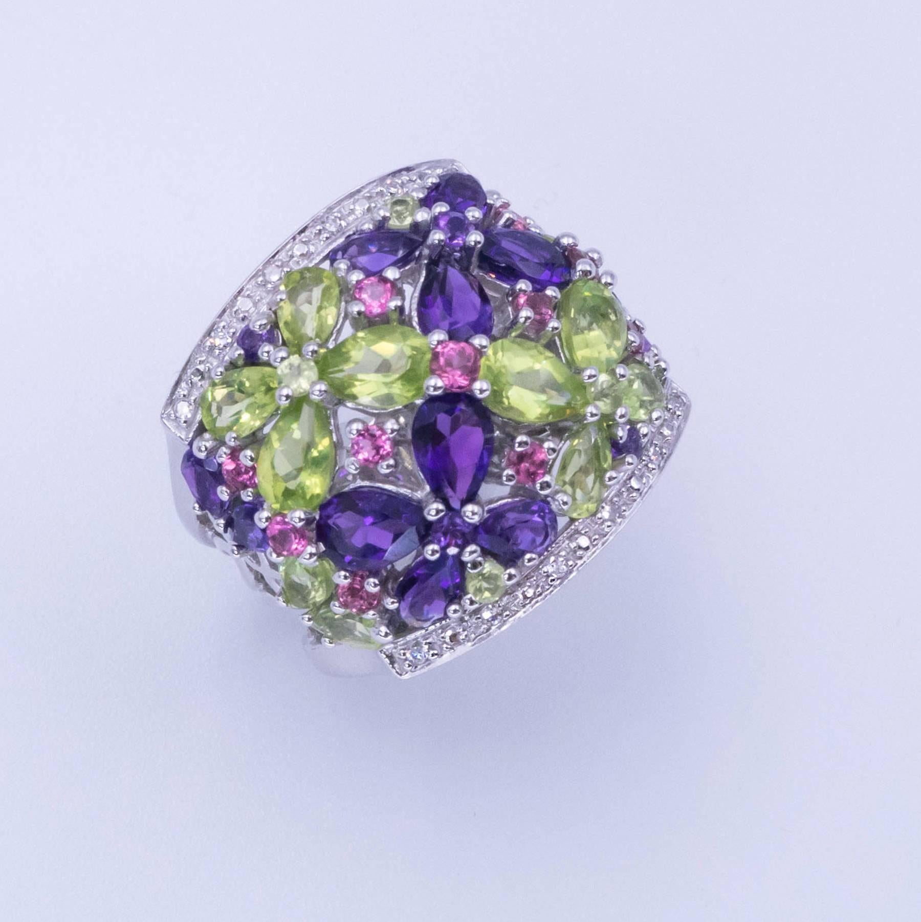 Sensational Amethyst Pink Tourmaline Peridot and Diamond Ring. This gorgeous wide band is set with Pear Cut Amethysts, Oval Cut Peridots, and Round Cut Pink Tourmalines and Diamonds depicting a stunning floral bouquet in a nicely detailed 14 karat