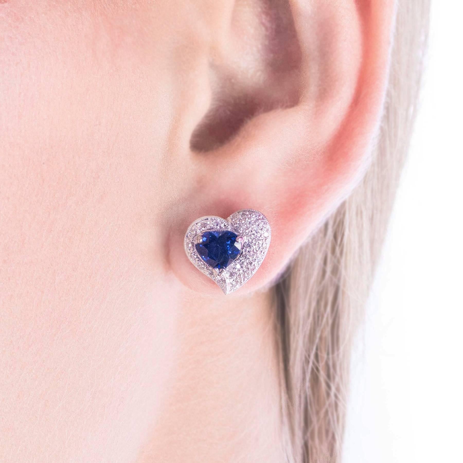 A stunning pair of 18 Karat White Gold Earrings are set with Heart Shaped natural Blue Sapphires surrounded by round, Brilliant Cut Diamonds.

These earrings will suit a lady who likes fabulous earrings on the smaller side.

CONDITION:  In overall