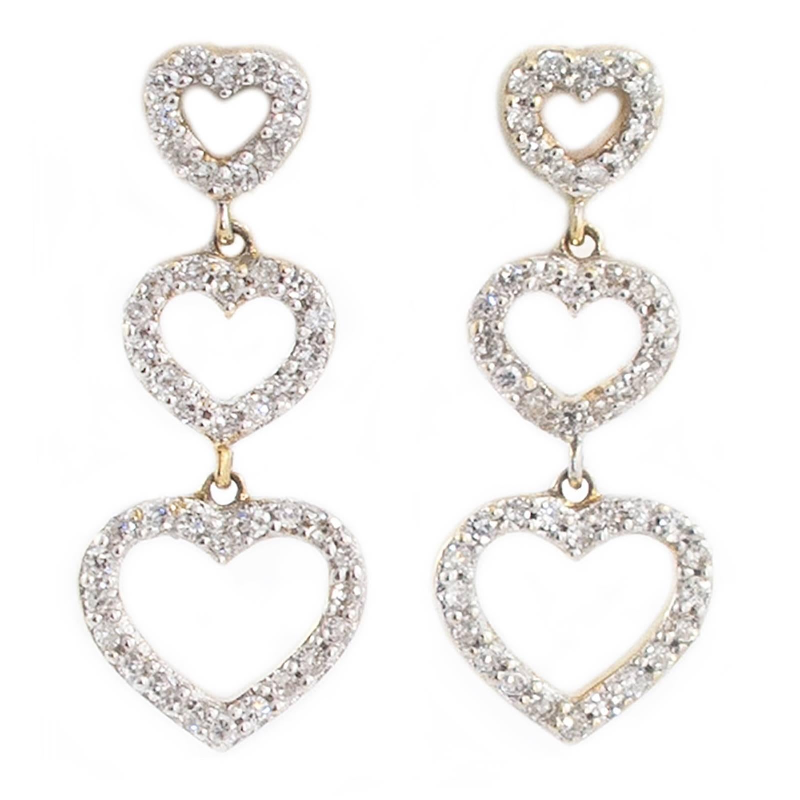 In these pretty Diamond Heart Drop Earrings, three open hearts are graduated and set with 90 Diamonds that total 1 carat. They hang just shy of one inch long and the bottom hearts measure 3/8th of an inch wide.

The earrings sit well on the ears and