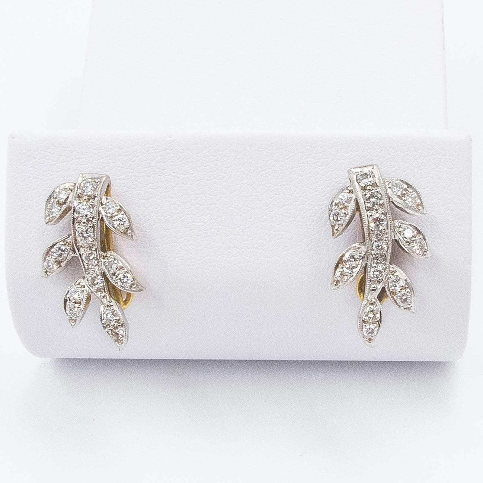 A pretty pair of 18K gold Art Deco Diamond Gold Earrings are set with 34 round, Brilliant Cut Diamonds in the form of open leaves on a vine. Designed to drop slightly below the bottom of the lobes from top mounted post and disc hangers.

Perfectly