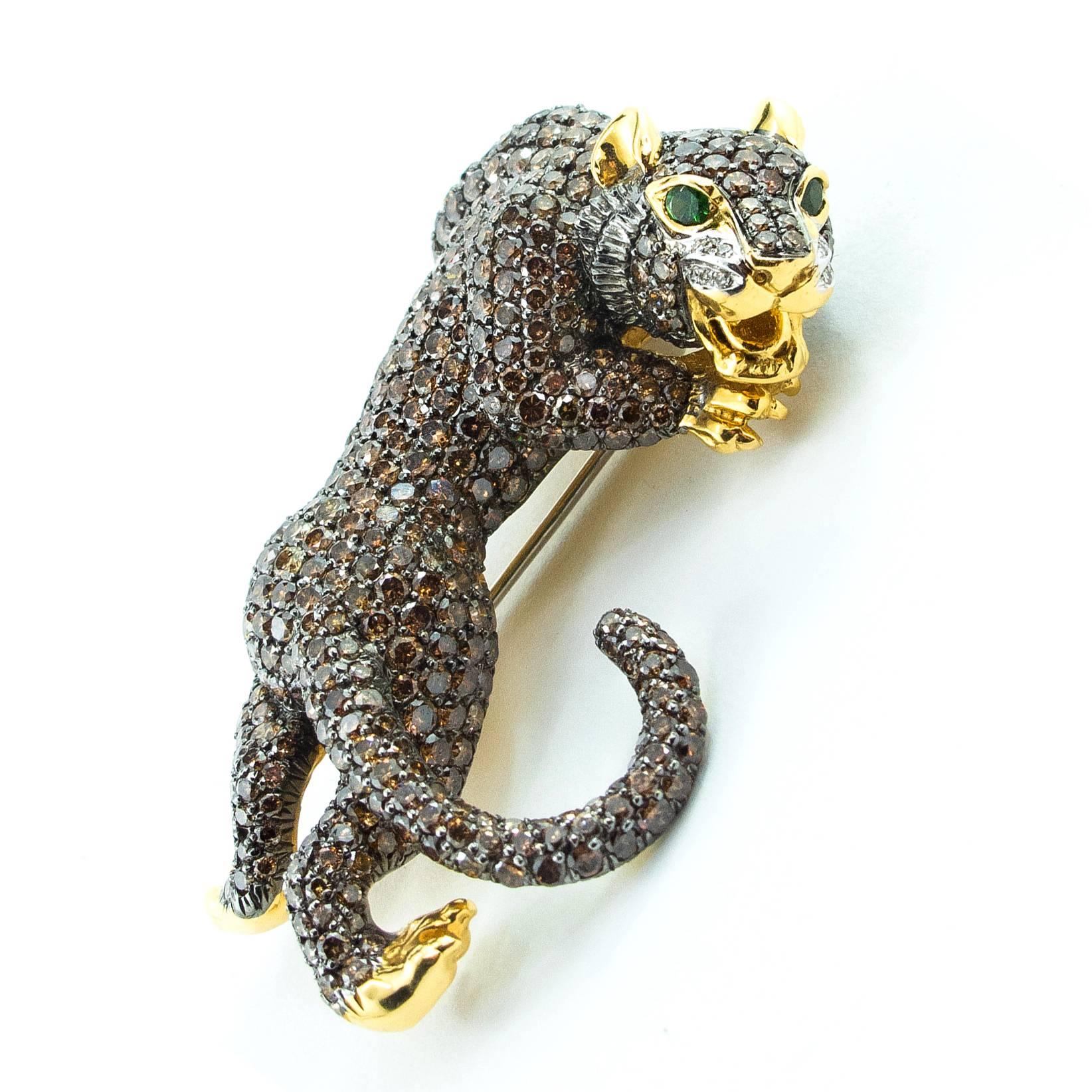 A fabulous 18 Karat gold brooch in the form of a playful young Panther is pave set with 490 Fancy Brown Diamonds, accented by 12 clear Diamonds and 2 channel set Green Garnets representing the eyes. 

The Panther is beautifully dimensional and