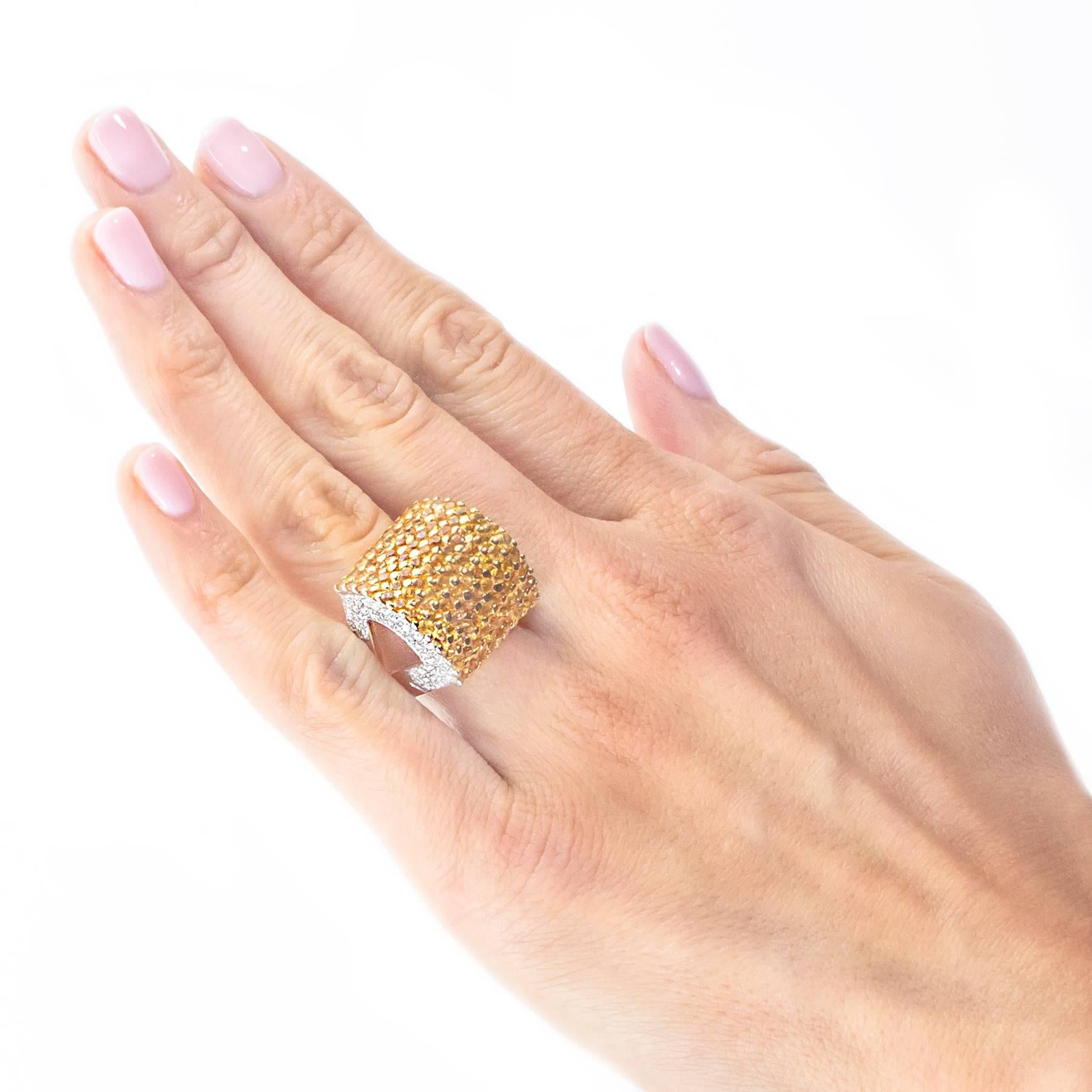 A dynamic dome shaped ring is pave set with 108 Yellow Sapphires/Corundums totalling approximately 4.33 carats. The sides of the dome contain 84 round, brilliant cut Diamonds weighing .67 carat.

The ring measures 18mm (approximately .75 inch) north