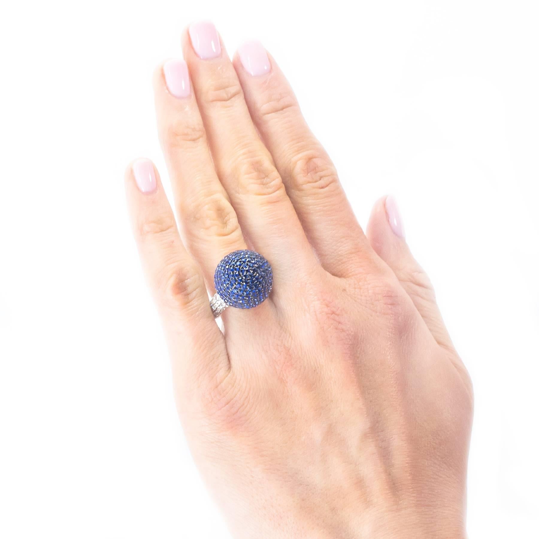 A gorgeous Blue Sapphire Diamond Ball Ring. The 15mm Blue Sapphire Orb is pave set with 5.08 carats of gemstones. It is flanked on each side by 56 round, Brilliant cut pave set Diamonds totaling approximately .56 carat.

The Orb is flattened at the