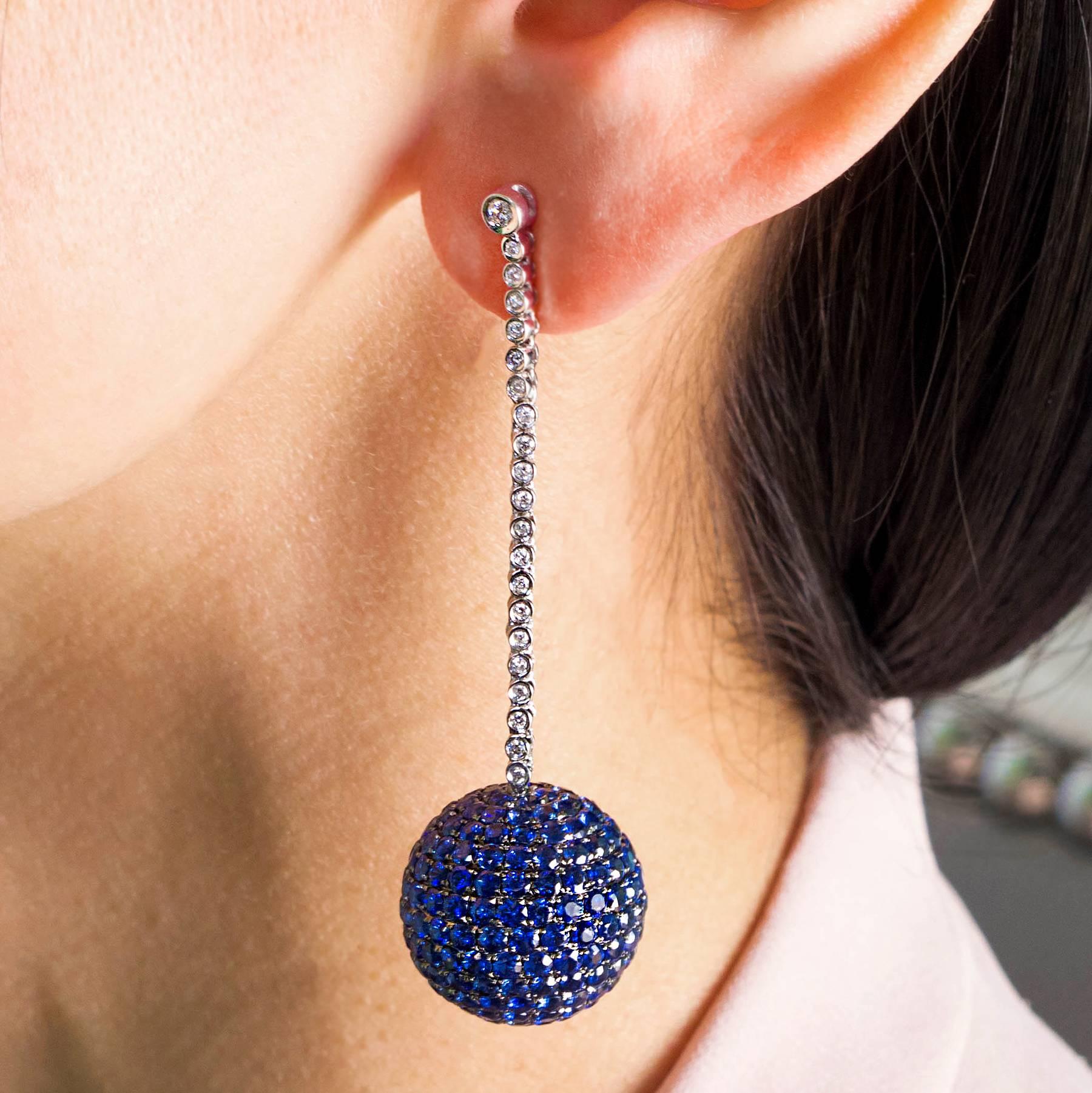 A pair of 20mm Blue Sapphire bead set orbs are suspended from flexible Diamond Line drops in these dramatic earrings.

The orbs hold 454 natural Blue Sapphires, totaling approximately 17.35 carats for the pair.

There are 42 round Brilliant cut