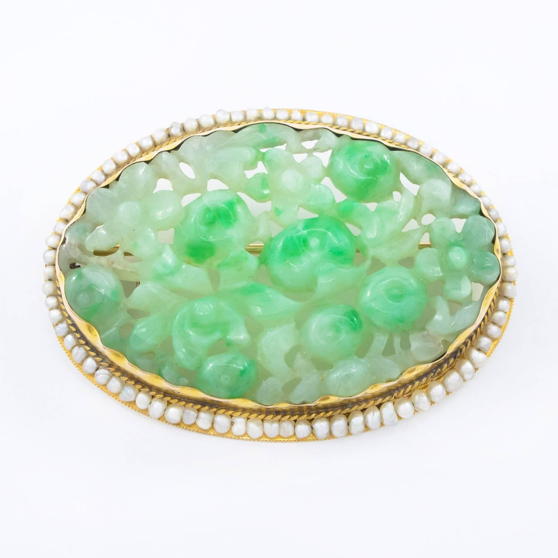 A 19th century carved and pierced oval Jadeite is White to Apple Green and quite large at 41.50mm x 28,00mm x 3.15mm.  It was originally mounted in a  high karat, push-over gold collar and later in the 19th, inset to an additional pink gold mount