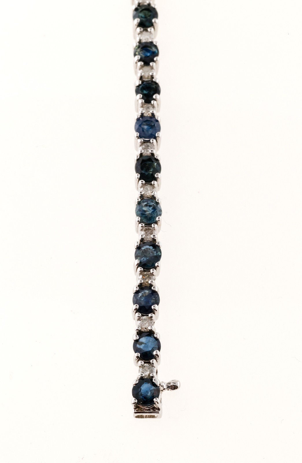 Hinged link 14k white gold bracelet with deep blue Sapphires and white diamonds.

26 diamonds approximately .03ct each, approximately .75ct total, H, SI2-I1
26 oval Sapphires 4 x 3.5mm approx. total weight 6.50cts
Stamped: 14k
Built in catch