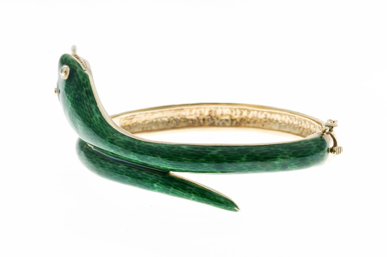 14k yellow gold green enamel diamond Snake hinged bangle bracelet. Green enamel top half and textured bottom half. Solid 14k yellow gold.

2 single cut round diamonds, approx. total weight .02ct, G, VS2
2 2 to 2.5mm Chinese white freshwater