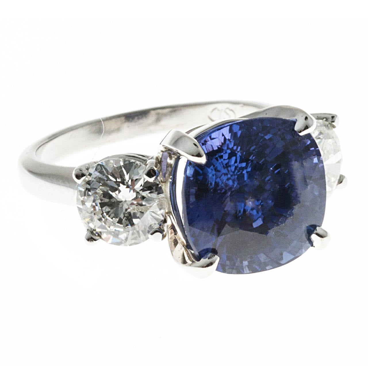 Saphir bleu à taille coussin certifié sans échauffement par Peter Suchy. 7,72ct avec un diamant blanc rond de taille brillant de chaque côté.  Monture en platine massif faite à la main. 

1 Saphir taille coussin, poids total approx. 7,72cts, 10,91 x