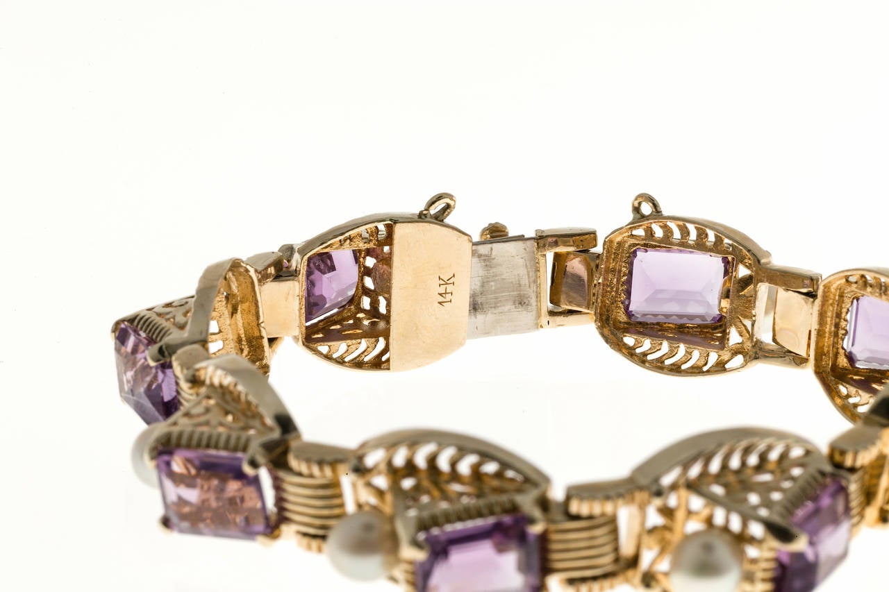 Outstanding 1940 Retro style emerald cut Amethyst and pearl bracelet. Very unusual filigree, angular design links with good pearls and amethyst. All hinges and links work well.  See our matching earrings.

8 emerald cut Amethyst approx. total