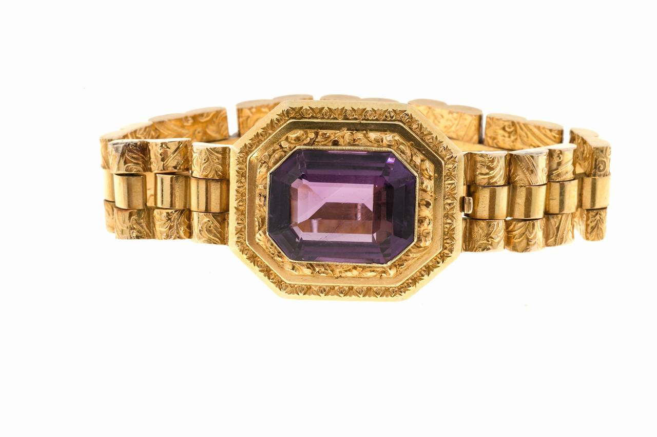 Authentic early 1900 hinged link bracelet hand engraved and chased throughout.  Beautiful bright purple genuine Amethyst in the clasp.

1 Amethyst modified emerald cut approx. total weight 10.50cts
14k Yellow Gold
Tested 14k
34.9 grams
1 1/16