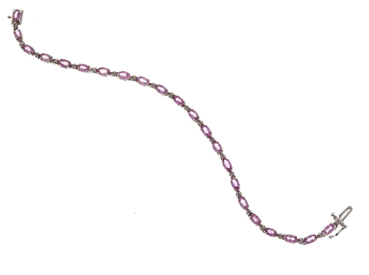 Classic 22 stone oval medium pastel pink Sapphire 7.70ct, 14k white gold bracelet with 10 diamonds. Hinged links. Invisible catch and side safety.

10 round diamonds approx. total weight .05cts, H, SI
22 oval pink Sapphires approx. total weight