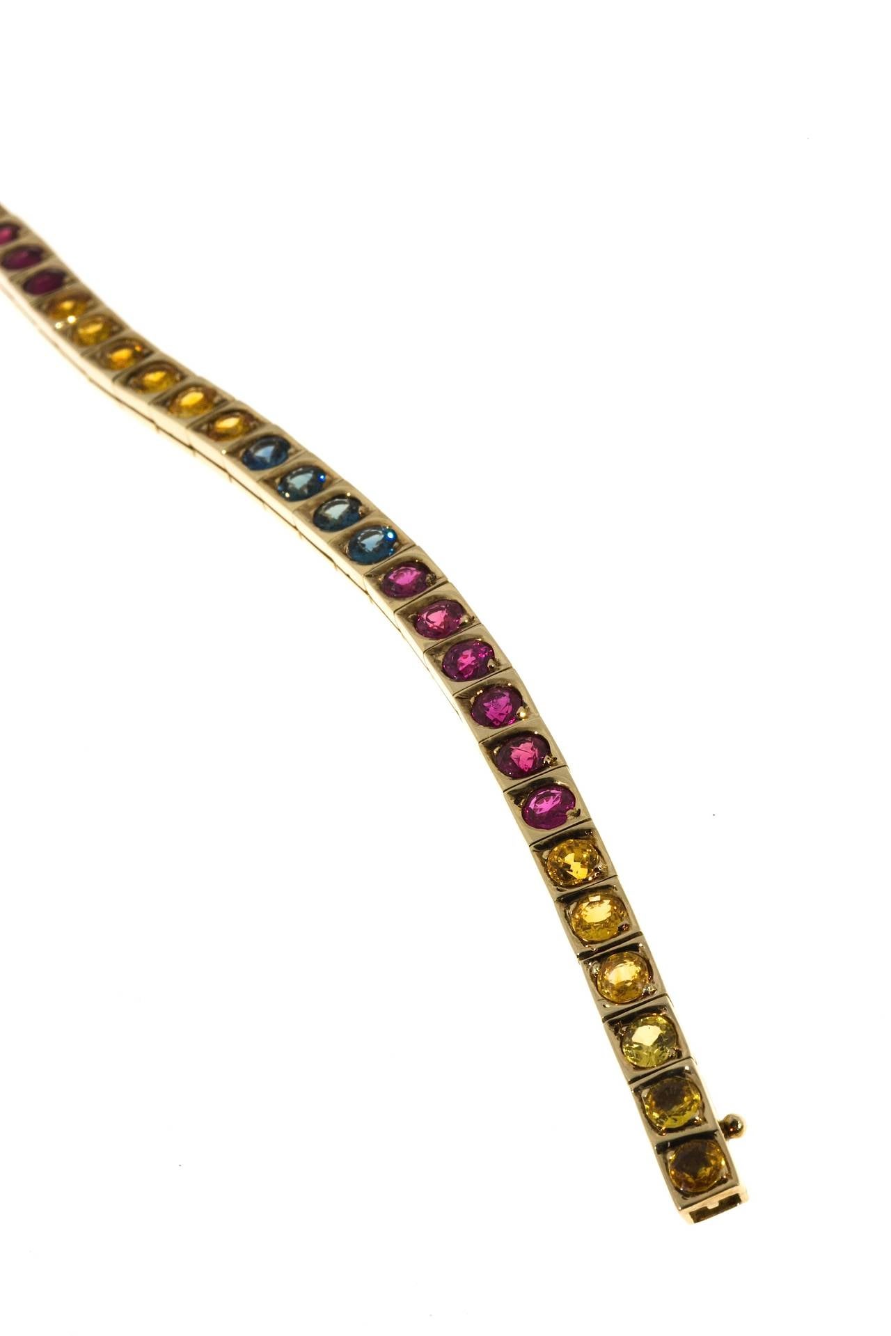 Hinged square box link bracelet with super bright well cut well blended all color Rubies and blue and yellow Sapphires. All GIA certified. The blue and yellow Sapphires are simple heat only. The Rubies are simple heat with minor residue. Hidden