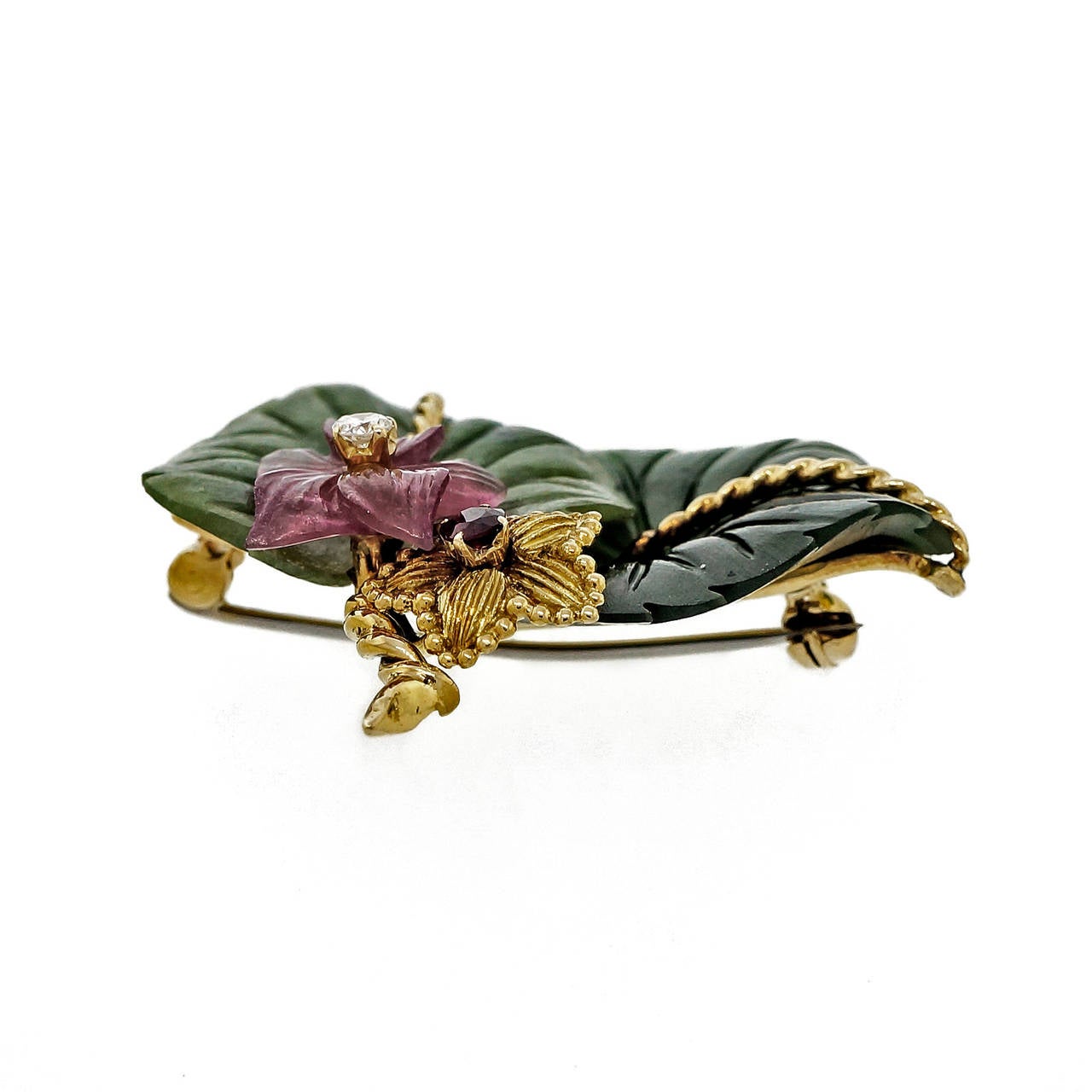1950s Tiffany & Co Jade leaf pin in 2 colors of Nephrite Jade, pink Tourmaline, fine Ruby and diamond.

1 round fine red Ruby, approx. total weight .10ct
1 round diamond, approx. total weight .06ct, H, SI
2 Jade flowers, approx. 22mm
1 pink