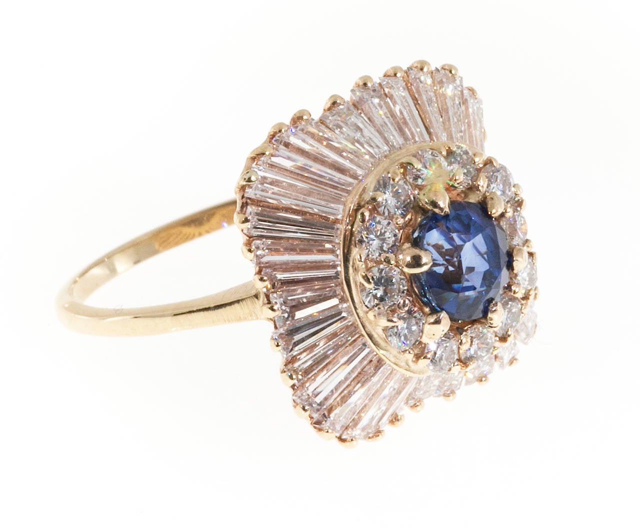 Ballerina style top quality  ring with custom unusually bright and vibrant baguette cut diamonds around the outside. The center has equally good round diamonds surrounding one of the finest sapphires that we have ever seen in years. The sapphire is