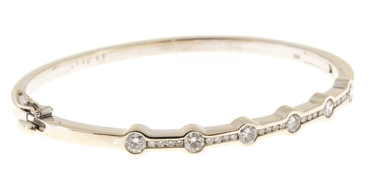 Solid construction bangle bracelet. Channel and bezel set with good quality diamonds. Very durable and comfortable. No prongs to catch on anything.

Diamonds 1.99cts
14k White Gold
Stamped 14k
18.5 grams
Inside Diameter: 6 ½ inches
Width: