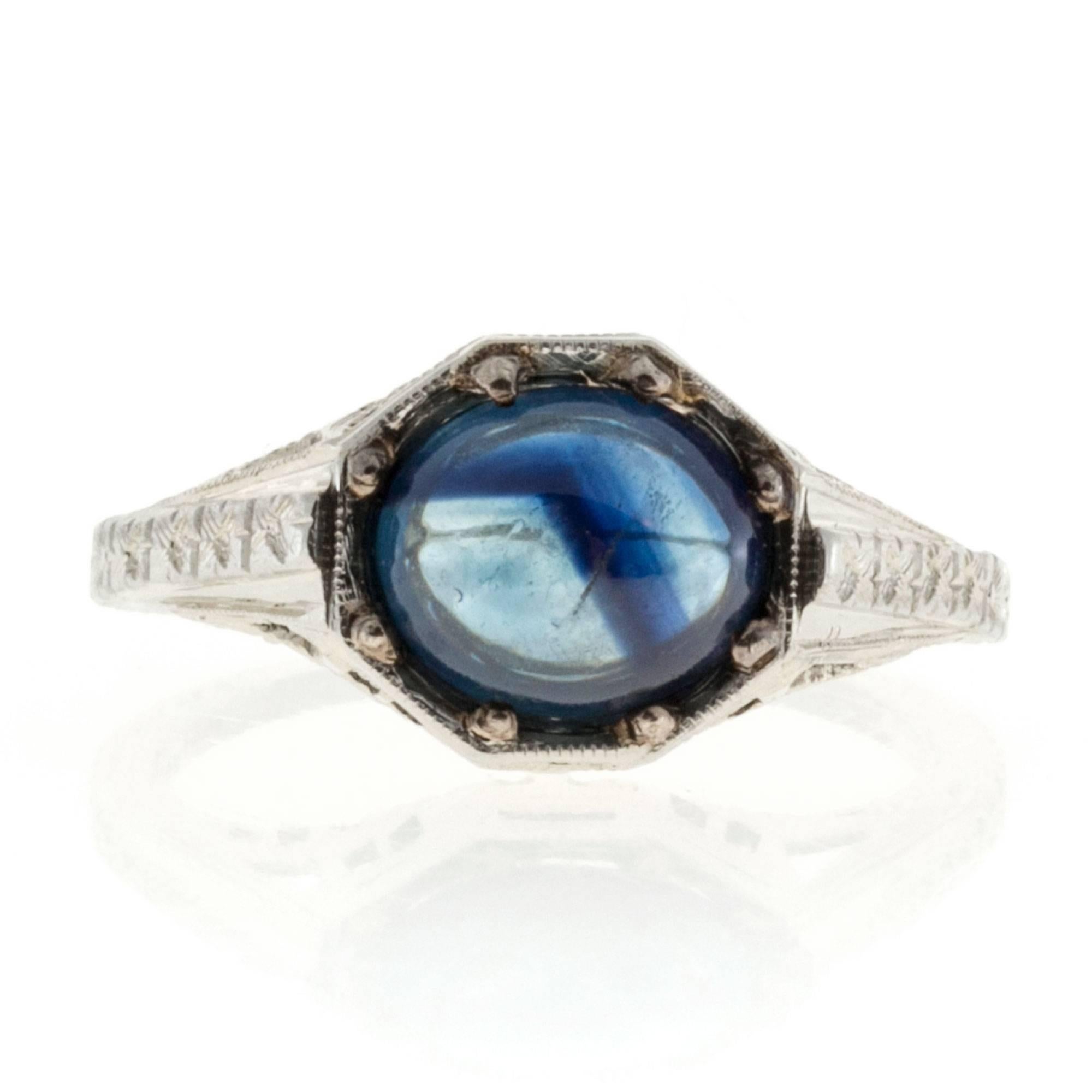 Art Deco handmade 18k white gold and Palladium hand engraved and hand pierced Filigree engagement ring.  The top is Palladium, the ring is 18k white gold.  The top is set with a bright blue oval fine natural sapphire cabochon. 

1 oval cabochon