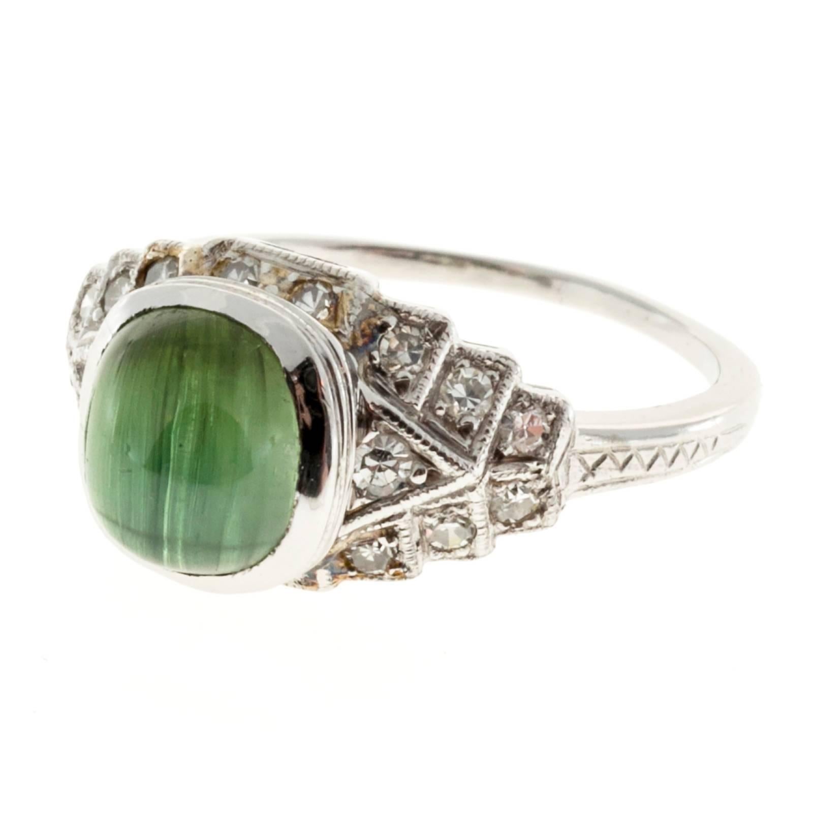 1920's Oval Tourmaline engagement ring with 18 diamonds in a platinum setting. 

1 genuine natural oval 2.10ct cat's eye Tourmaline.
18 diamonds, G, VS1- SI, .22cts
Platinum
5.0 grams
3/8 inch wide
Size 6 and sizable
