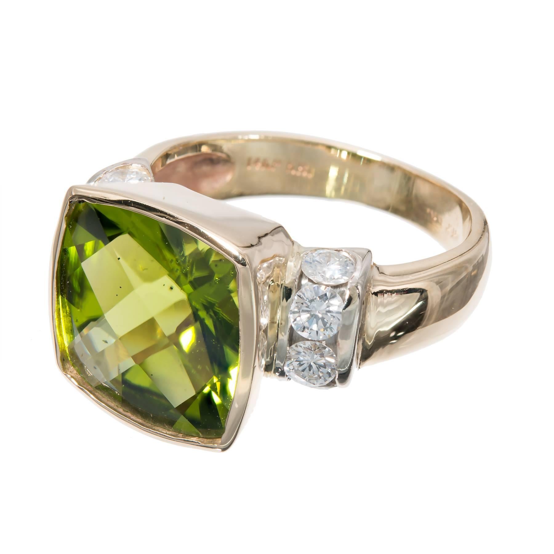 Fine rich bright green cushion Peridot in a full bezel and flanked by 8 round full cut diamonds. Yellow and white gold setting. 

1 square custom fine rich green Peridot, approx. total weight 6.62cts
8 round full cut diamonds, approx. total