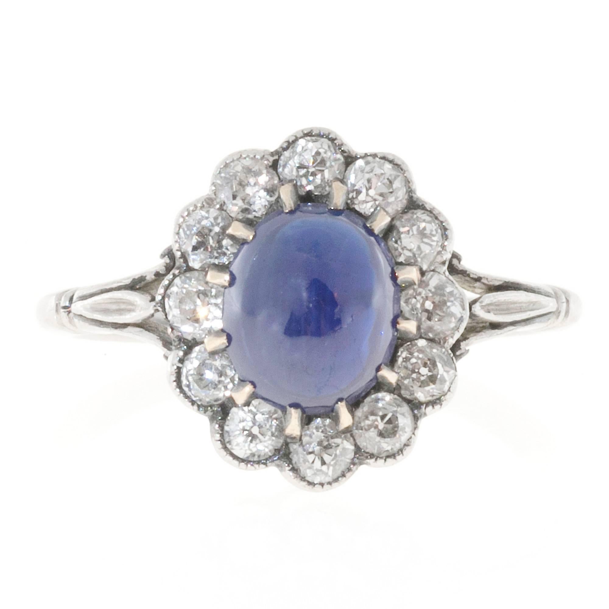 Platinum engagement ring circa 1910-1920 with old mine cut diamond halo and a high dome natural sugar loaf cornflower blue cabochon Sapphire.

1 Oval natural cabochon Sapphire 7.9 x 6.6 x 3.9mm, CMG Type II inconclusive approximately 1.75ct. Extra