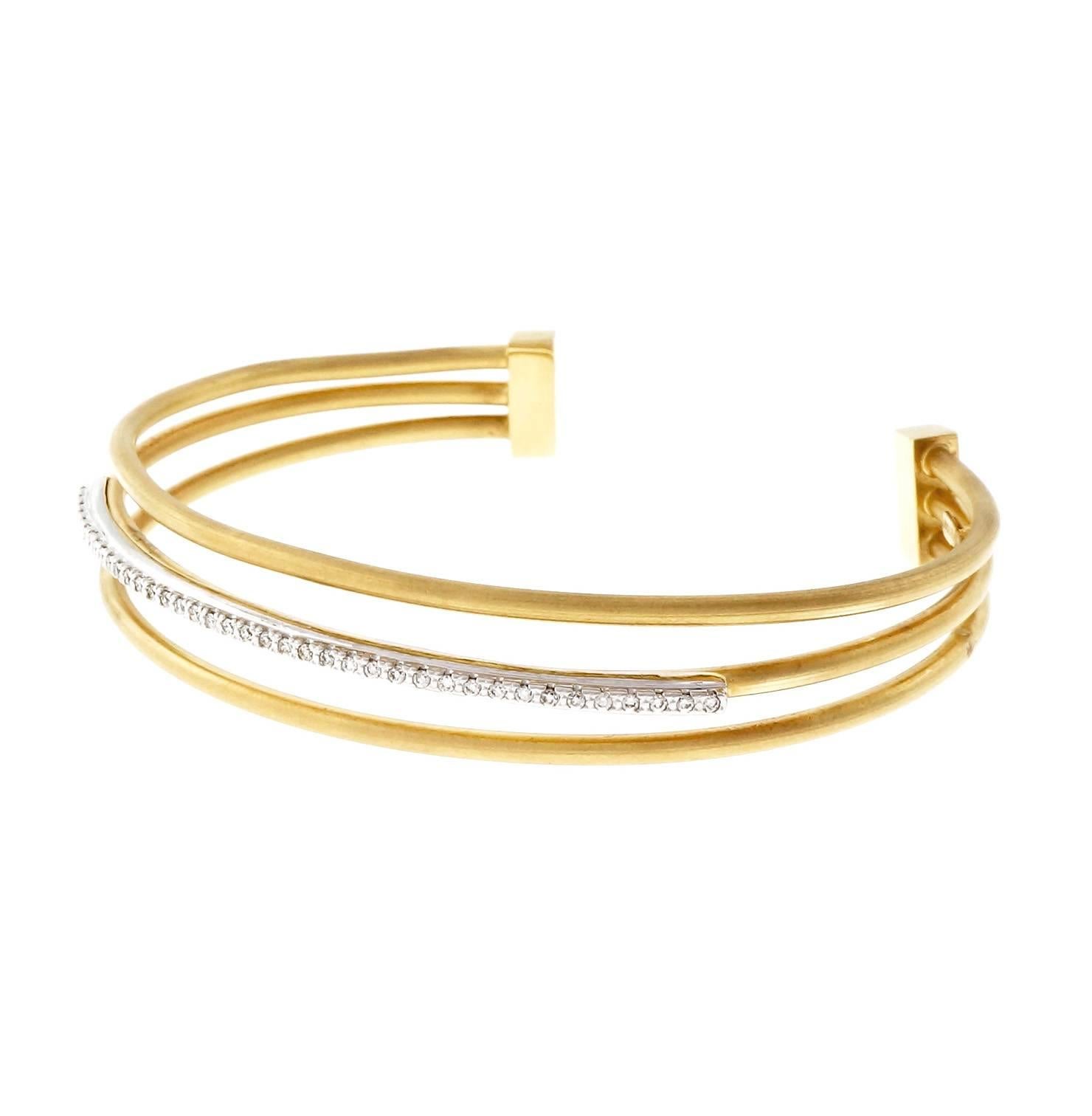 Designer Isaac Reiss 3 row diamond center row slip on bangle bracelet.

39 round diamonds, approx. total weight .33cts, G – H, VS
14k yellow and white gold
Tested and stamped: 14k
Hallmark: I. Reiss
14.0 grams
Fits a standard 7 to 7 1/2 inch