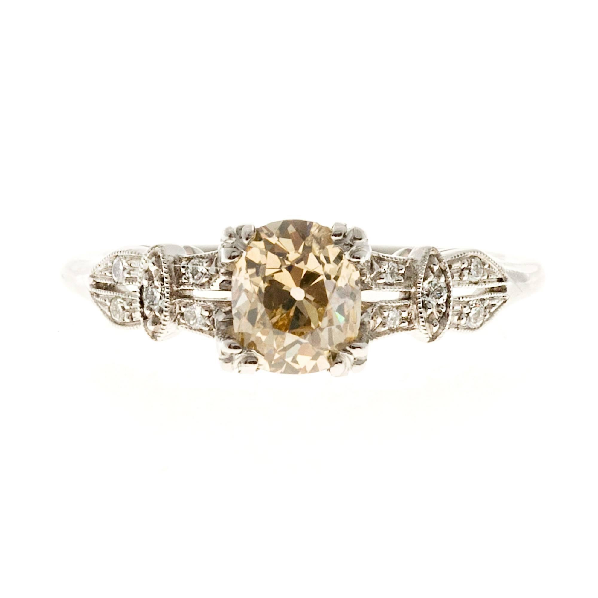 Natural GIA certified fancy light yellow brown cushion cut diamond with accent diamonds on shank. Set in an antique ring from the Peter Suchy Workshop PSD.

1 cushion diamond, approx. total weight .85cts, SI2, fancy light yellow brown, GIA