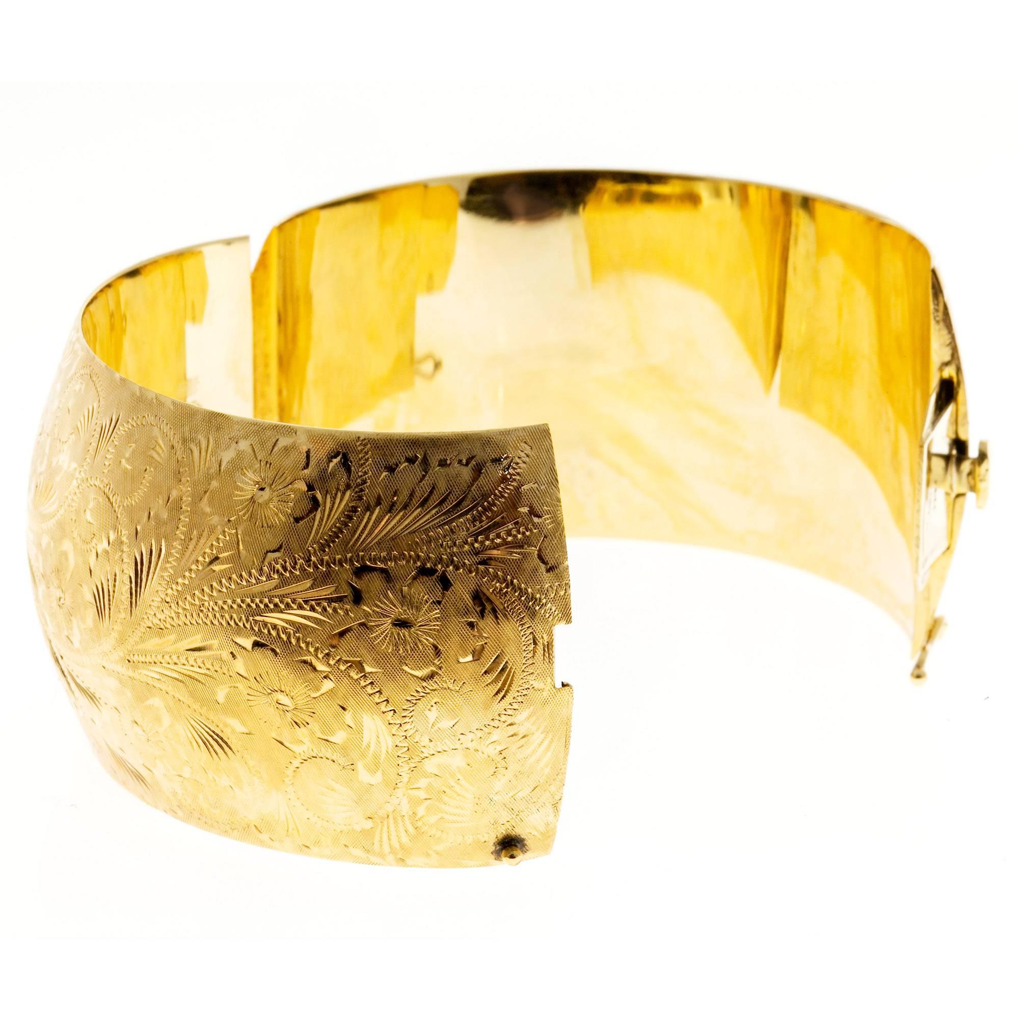 Extra wide beautifully hand engraved 1960’s bangle bracelet. Floral engraving all around. Figure 8 safety. Secure catch and hinge.

14k yellow gold
75.3 grams
Tested and stamped: 14k
Hallmark: MS
Stamped: 5.93mm
Inside dimensions: 2.38 x 2.06