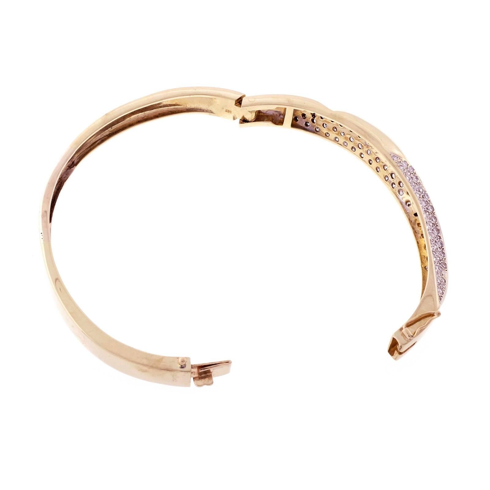 Oversize solid 14k gold swirl design hinged bangle bracelet with 2 Pavé diamond sections. Rhodium on diamond sections.

100 round diamonds, approx. total weight 2.00cts, H – I, SI
14k yellow gold
Tested and stamped: 14k
36.9 grams
Inside