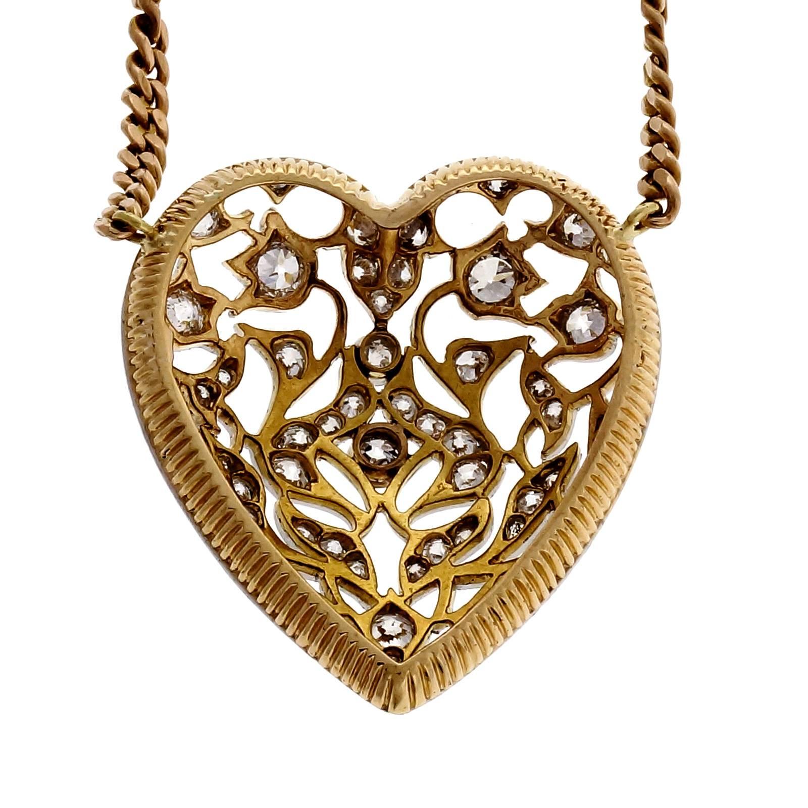 Open work vine and flower design full size heart pendant in 14k gold with Platinum top bead set with old European cut diamonds and attached to a handmade link chain 22 inches long. Circa 1920.

60 round old European cut diamonds, approx. total