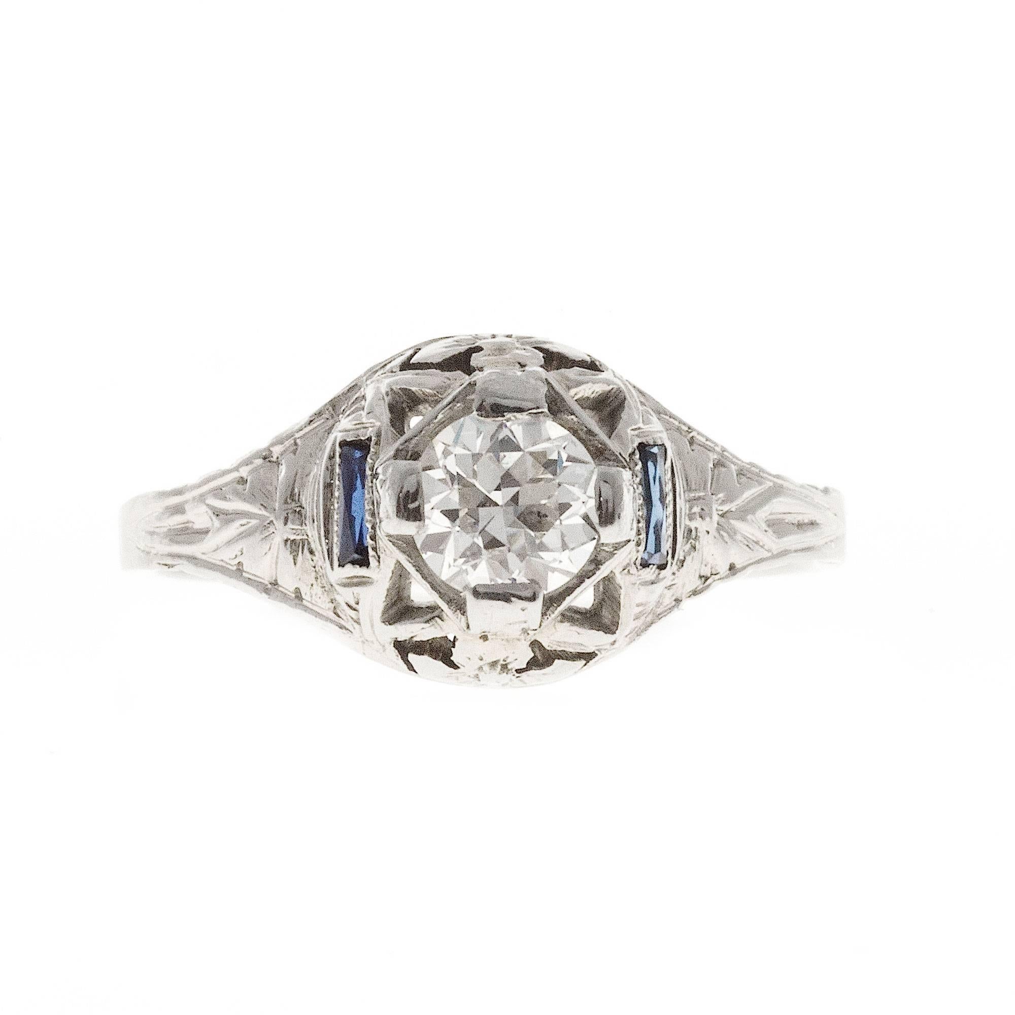 1930 18k white gold filigree engagement ring with Sapphire Baguettes and a bright sparkly old European cut transitional cut diamond.

1 transitional round diamond, approx. total weight .40cts, F – G, SI1, 
2 Calibré cut Sapphires, 3.17 x 1.10 x