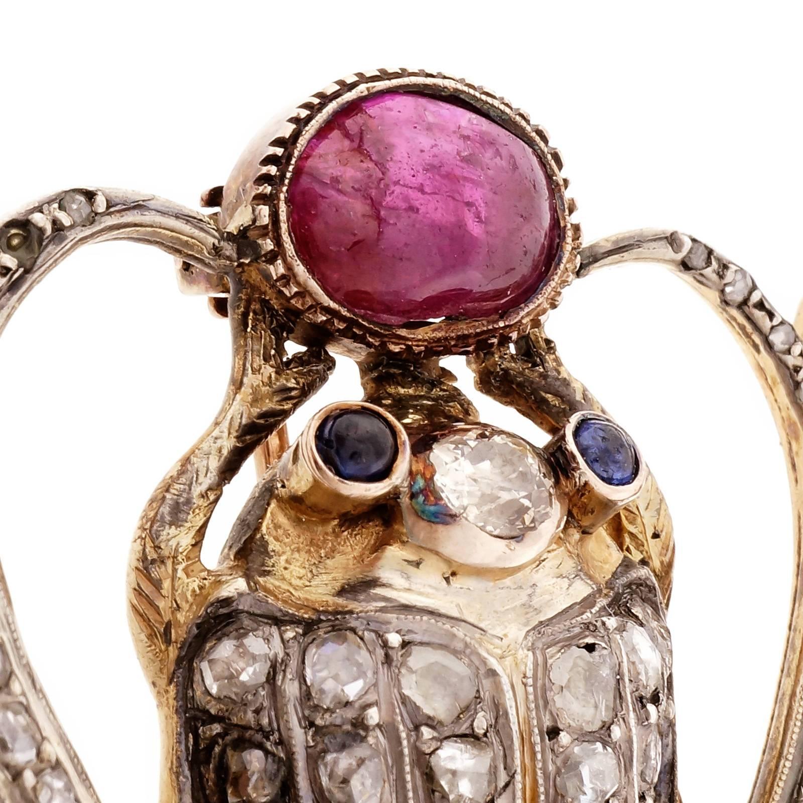 1920-1930 Egyptian Revival silver and gold pin with genuine ruby and Sapphire accents. Rose cut and old mine cut diamonds and a GIA certified natural saltwater pearl. 14k hinge and 10k pin stem.

1 old mine diamond, approx. total weight .25cts,