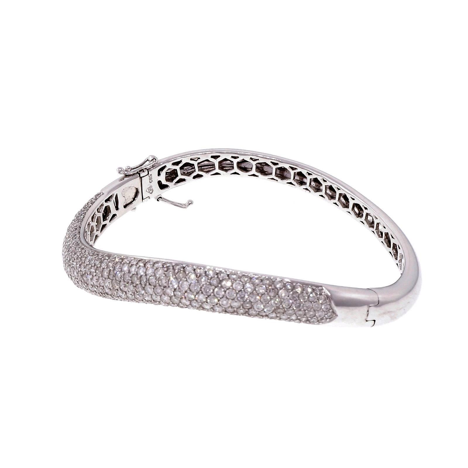 Curved swirl design domed diamond Pavé hinged bangle bracelet stamped Ed. Secure catch and 2 figure 8 safety catches.

322 round diamonds, approx. total weight 6.02cts, G, VS – SI
14k white gold
Tested: 14k
Stamped: 585
Hallmark: Ed
19.6