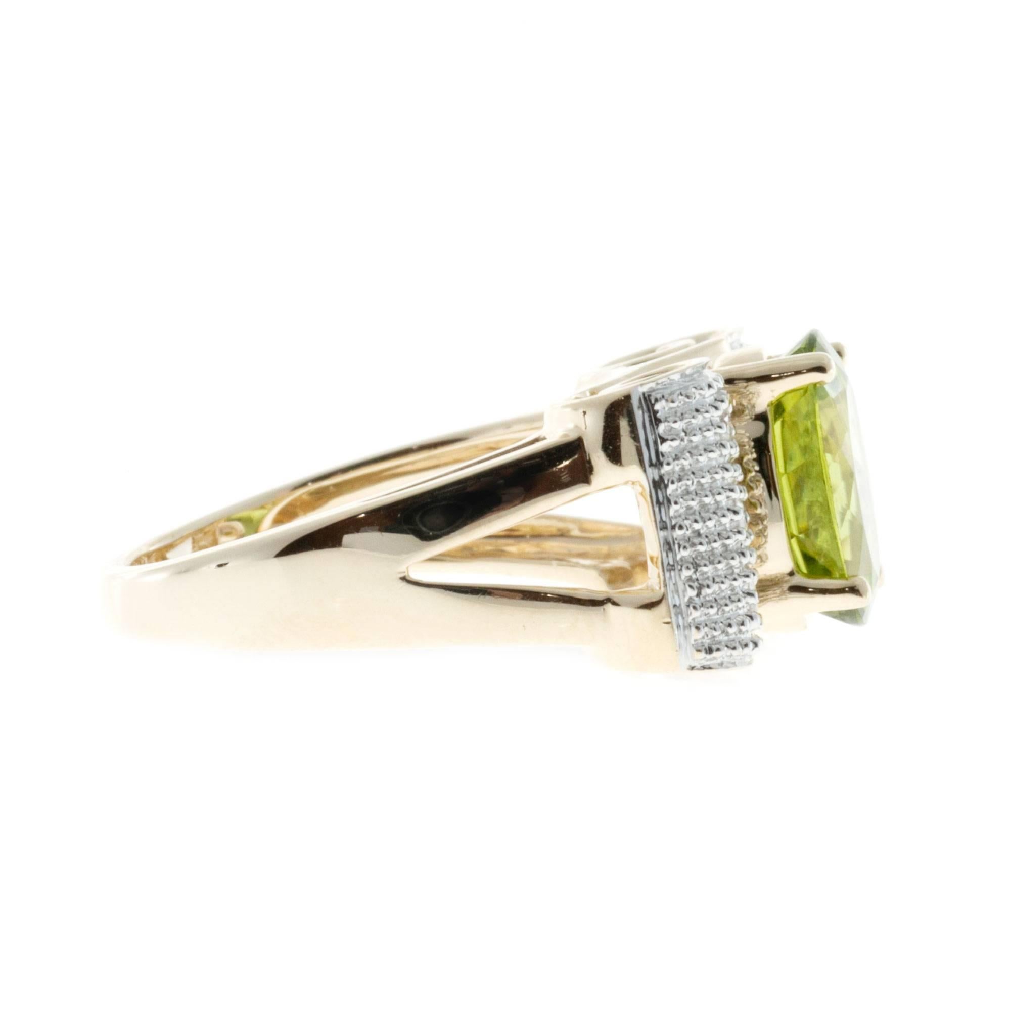 Asymmetrical swirl design ring in 14k yellow gold with diamonds set in white gold and a bright medium green Peridot.

1 oval green Peridot, approx. total weight .30cts, VS, 10.87 x 8.83mm
10 round diamonds, approx. total weight .10cts, H, SI
Size 8