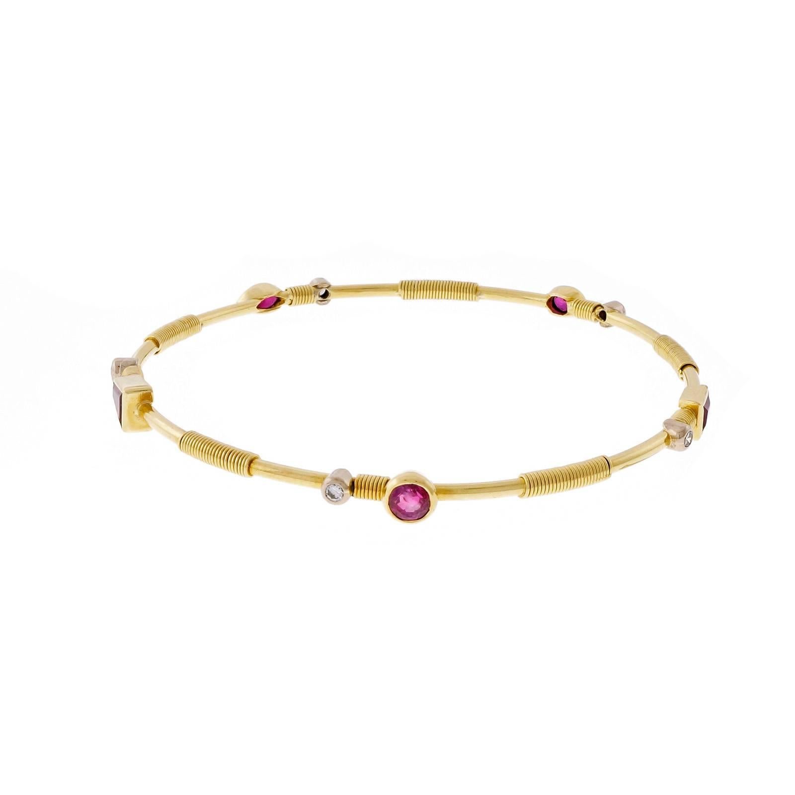 Handmade solid 18k yellow gold slip on bangle bracelet with bright red multi shaped genuine Rubies, diamond and twisted wire accents.

1 round red Ruby, approx. total weight .33cts, SI, 3.95mm
1 Marquise Ruby, approx  .31ct total weight. 5.3 x