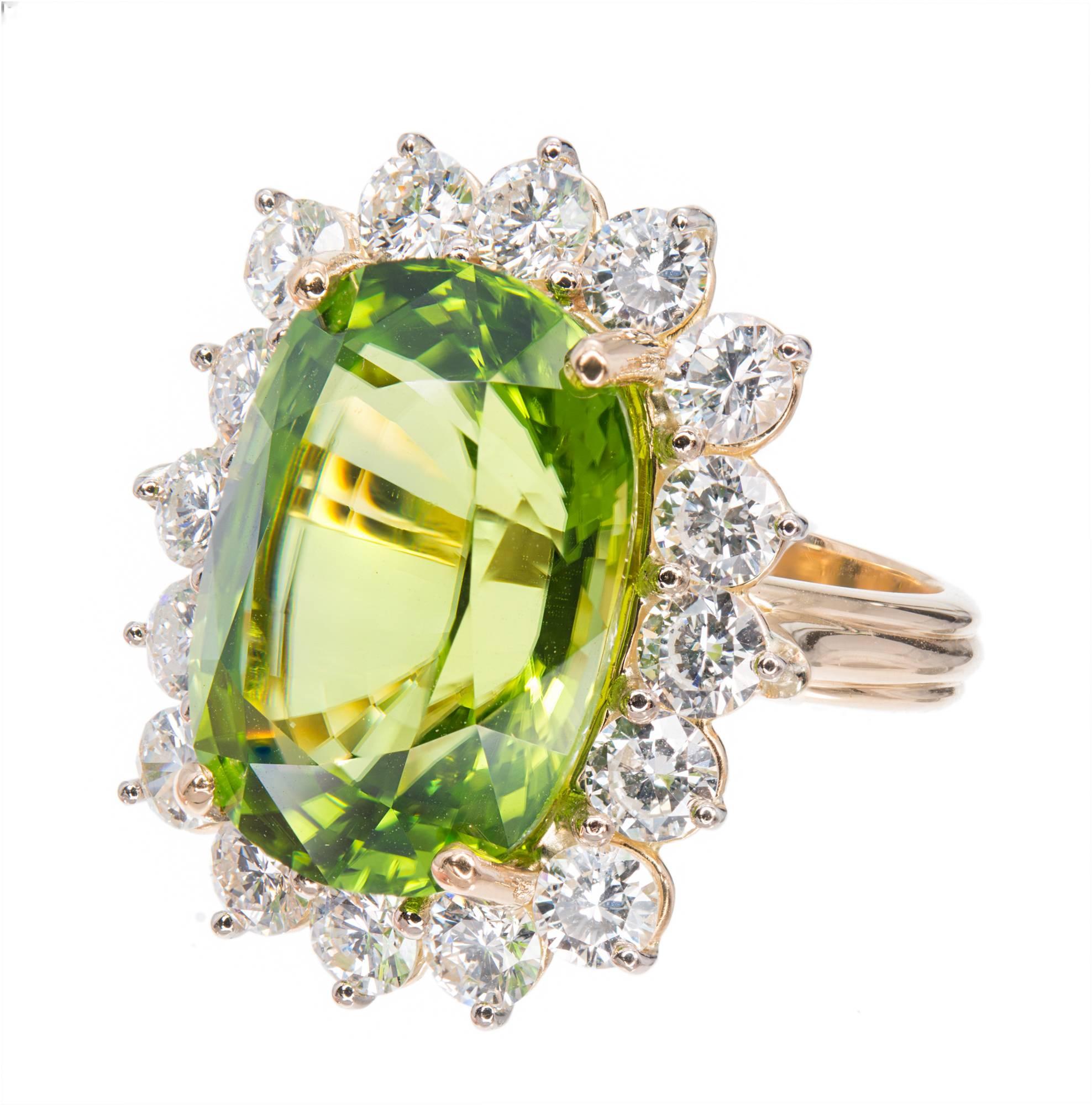 Large cushion Peridot and diamond cocktail ring. GIA certified cushion cut  green with hints of yellow, oval center stone with a halo of 16 round diamonds in 18k yellow and white gold setting. The ring was designed and made in the Peter Suchy