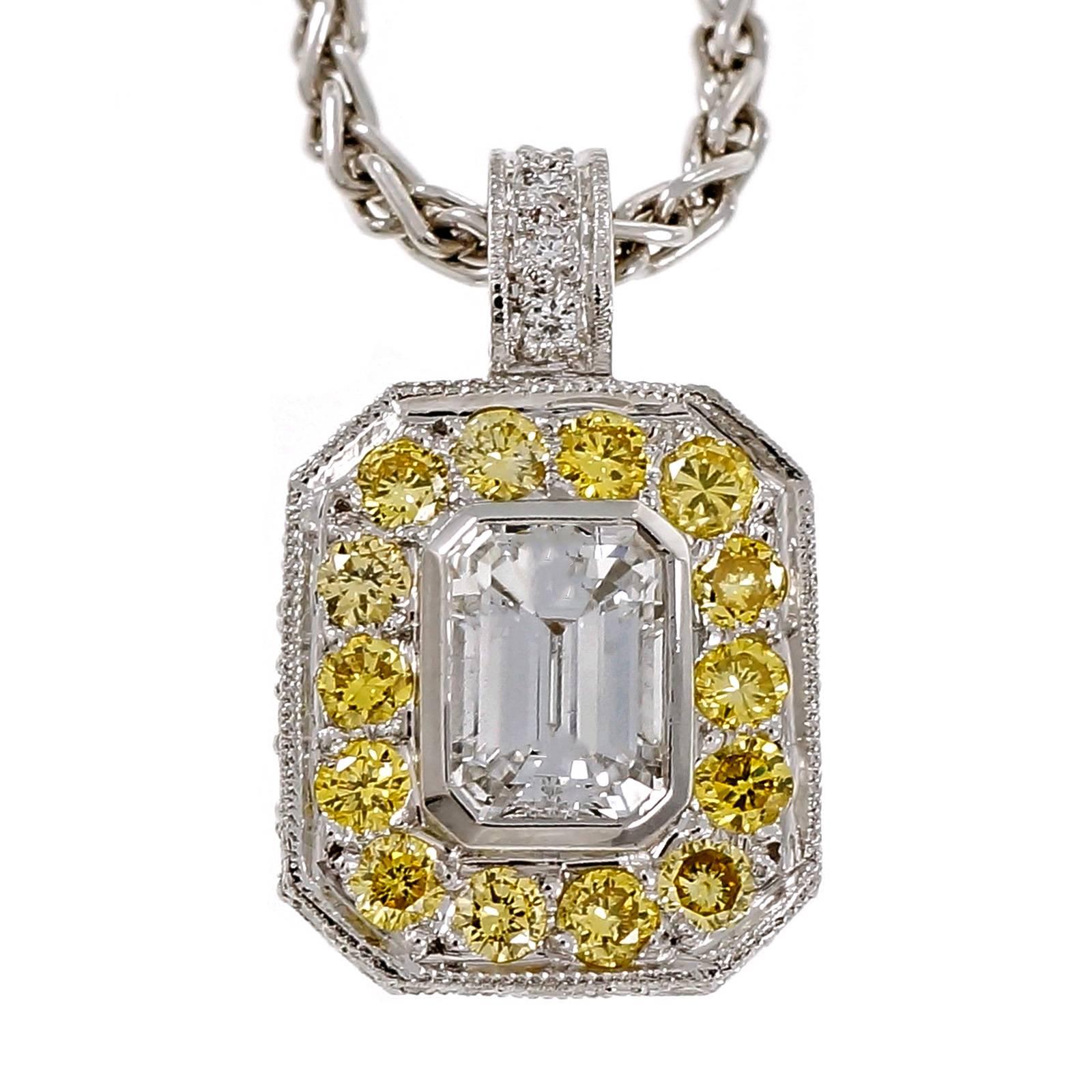 Peter Suchy Platinum pendant with a colorless high grade Emerald step cut diamond circa 1920 surrounded by natural fancy intense yellow diamonds in an octagonal pendant on a Platinum wheat chain.

1 Emerald cut diamond, approx. total weight