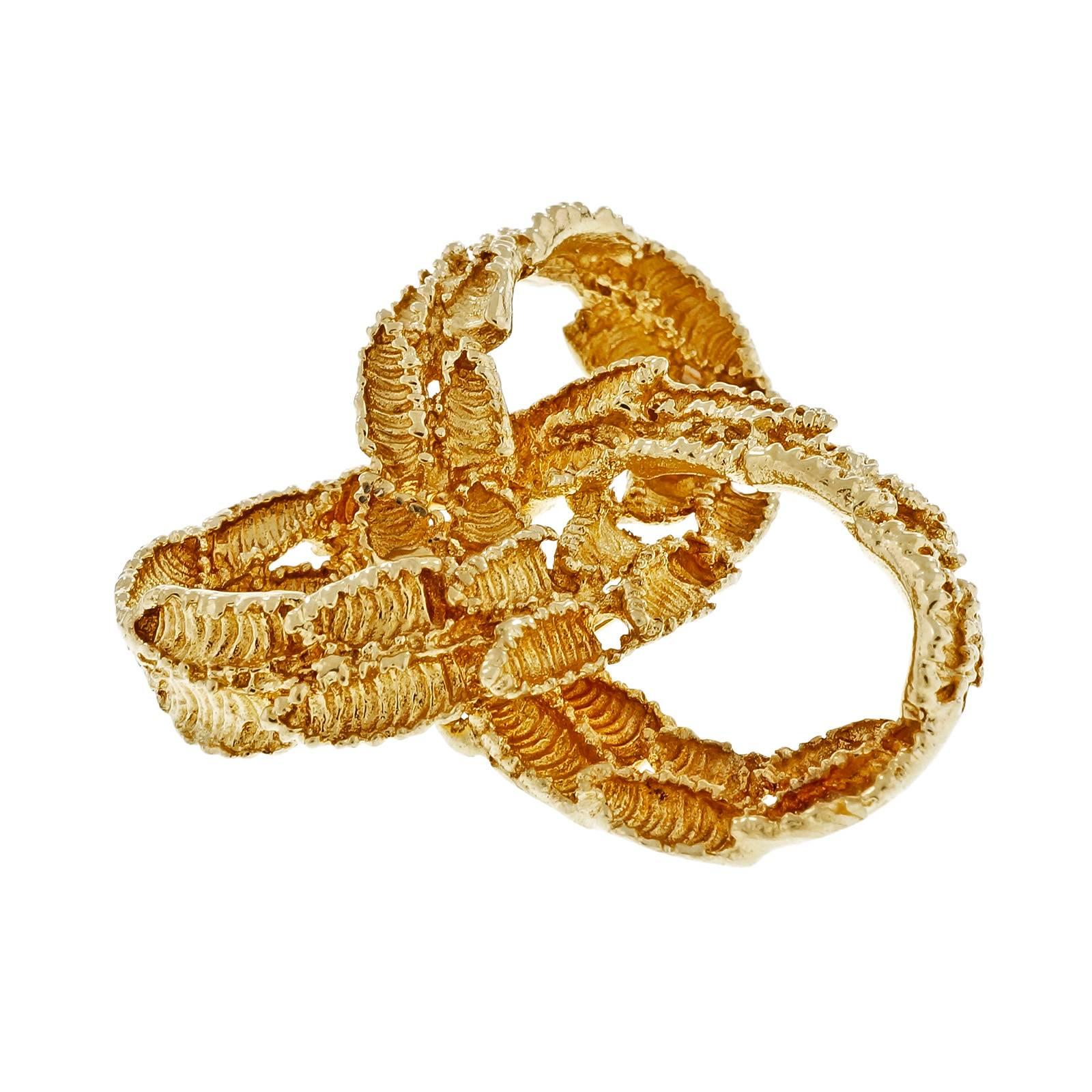 Tiffany & Co textured vintage 1960's Infinity Knot Brooch in solid 18k yellow gold.

18k yellow gold
Tested: 18k
Hallmark: Tiffany & Co
19.1 grams
Top to bottom: 39.09mm or 1.54 inches
Width: 38.76mm or 1.53 inches
Depth: 14.15mm

