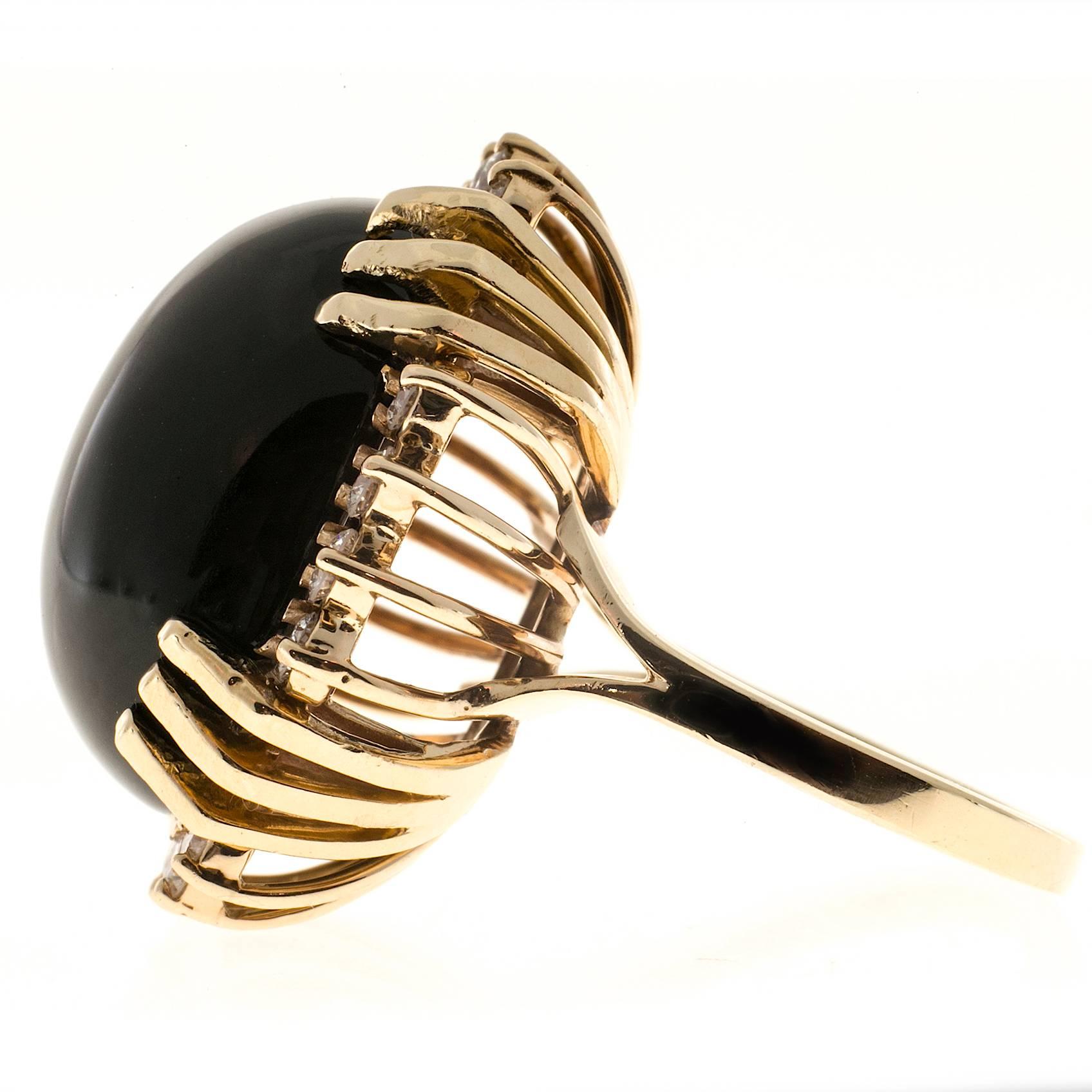 1960 high dome well-polished black Onyx with bright shiny well cut diamonds around it in a 14k yellow gold setting

1 oval black Onyx, approx. total weight 18cts, 21 x 17.6 x 8mm
16 full cut round diamonds, approx. total weight .80cts, H, VS1 to
