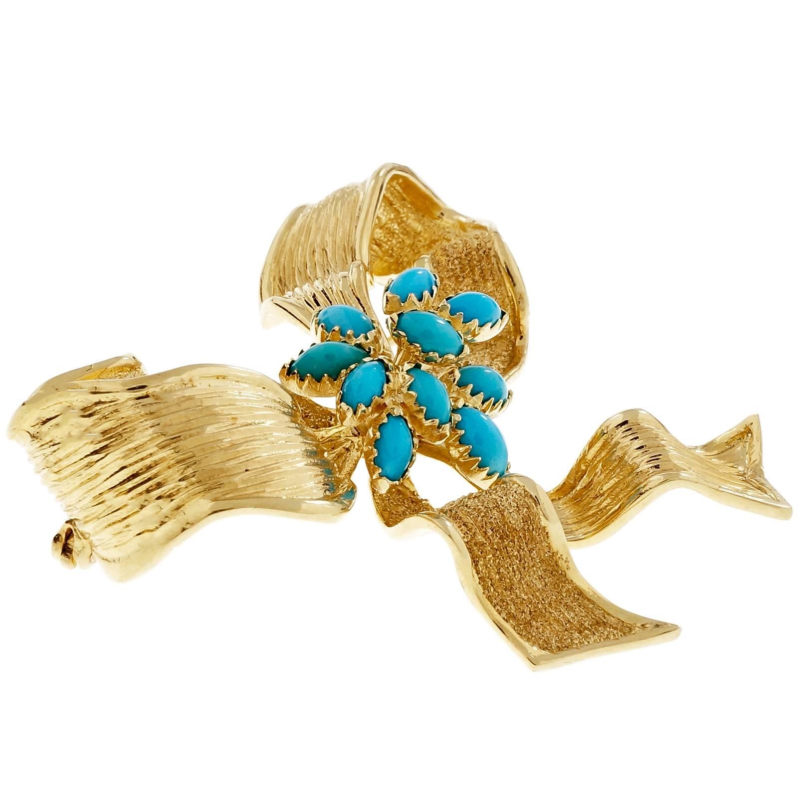 GIA certified Persian turquoise textured yellow gold bow brooch. Crafted with 1950's precision and artistry, this brooch features 9 cabochon marquise shaped turquoise, set in a 14k yellow gold. The textured details add a touch of sophistication and