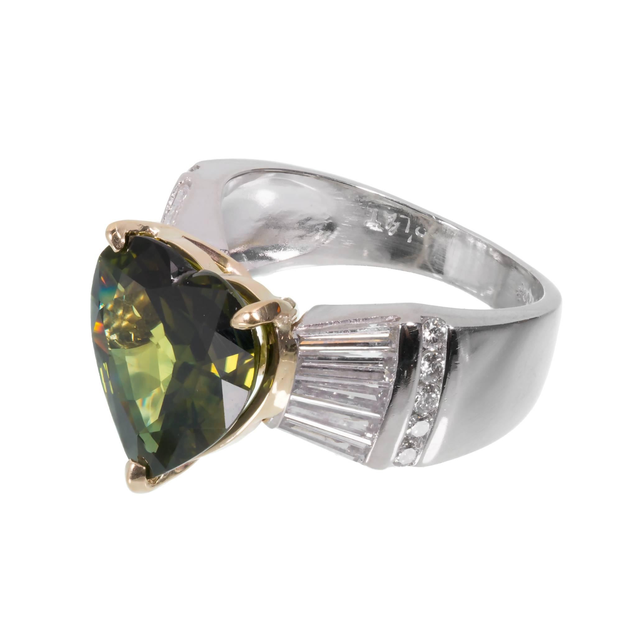 Green sapphire and diamond engagement ring. GIA certified heart shaped green sapphire center stone with 20 round and tapered baguette accent diamonds in Platinum and 18k yellow gold setting. Certified natural conundrum by the GIA as simple heat