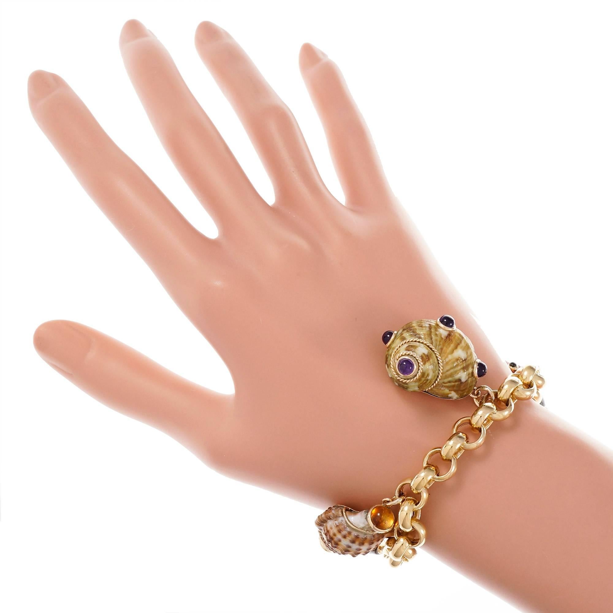 Sea shell designer MAZ multi-color shells accented with gold beads in 14k and natural gemstones. The charms are attached to an Italian made 18k yellow gold bracelet.

14k & 18k yellow gold
4 round cabochon purple Amethyst, 3.88mm
5 natural multi