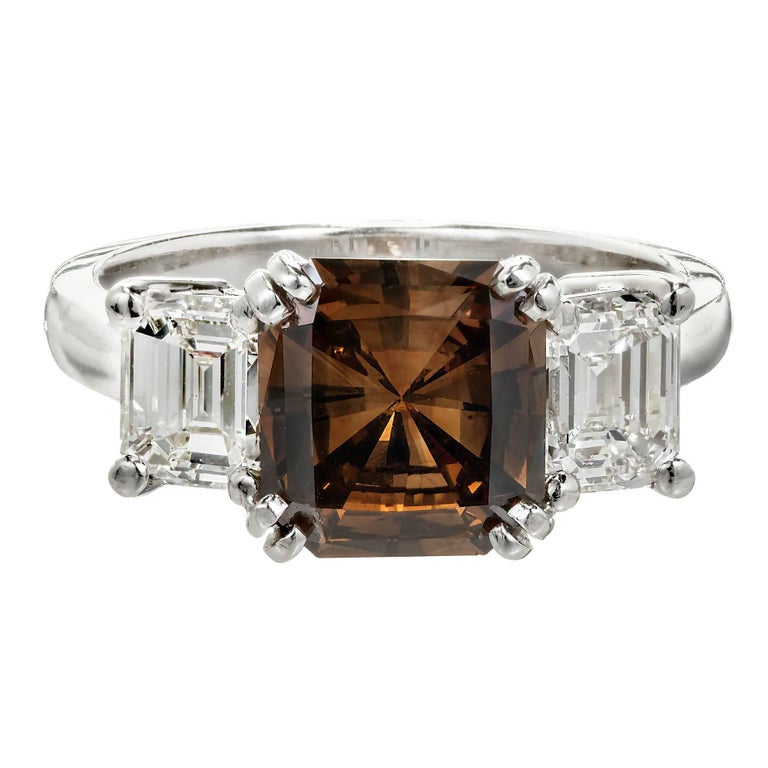 Natural fancy dark orange brown modified radiant cut 2.14ct three-stone diamond engagement ring. Brown center stone with two white side diamonds in a platinum setting handmade in the Peter Suchy workshop for these stones.

1 diamond 2.14cts, fancy