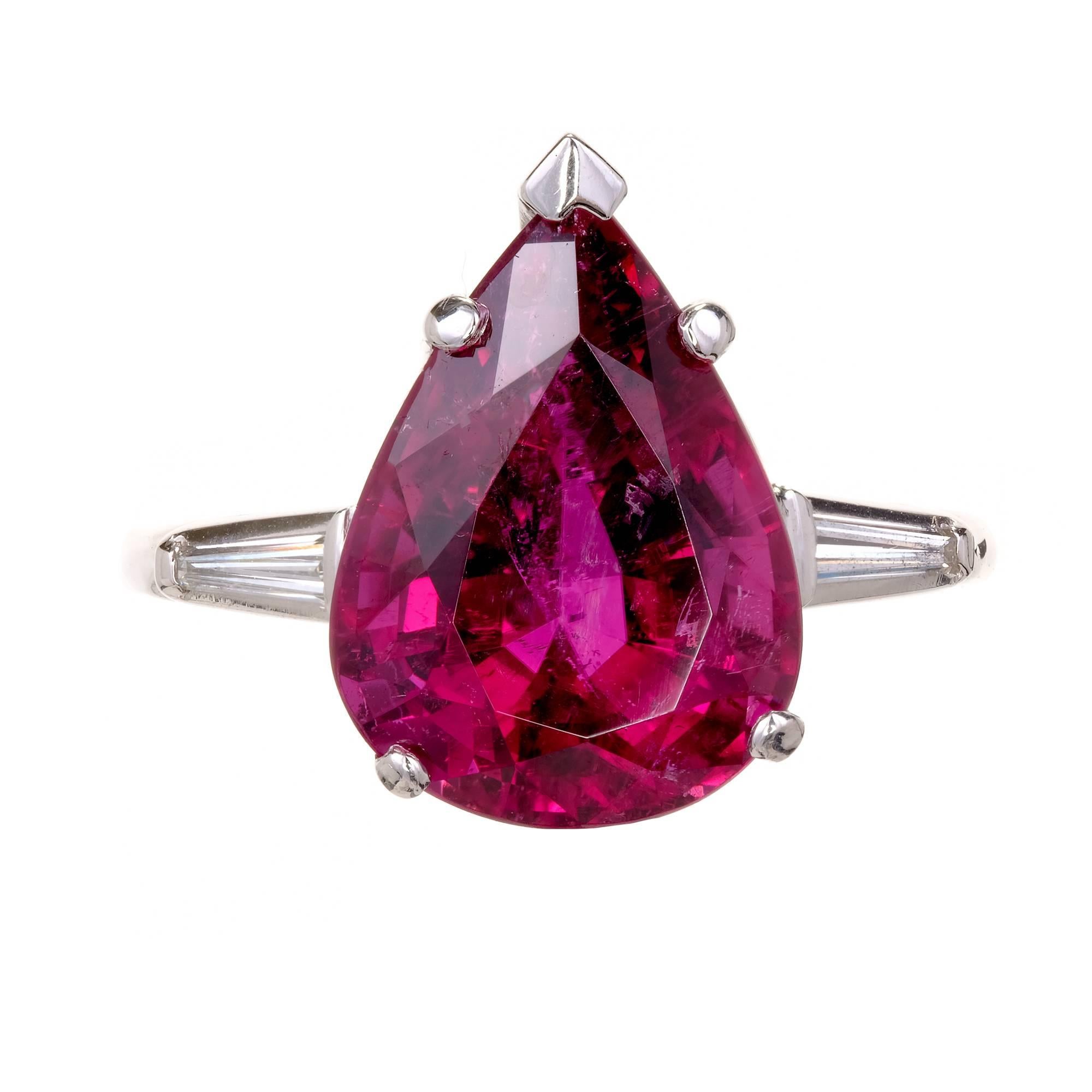 Mid-century large pear shaped three-stone gem red Rubellite Tourmaline Platinum cocktail ring with tapered baguette accents. 

1 pear shaped pink Rubellite Tourmaline, approx. total weight 6.95cts 
2 tapered baguette diamonds, approx. total weight