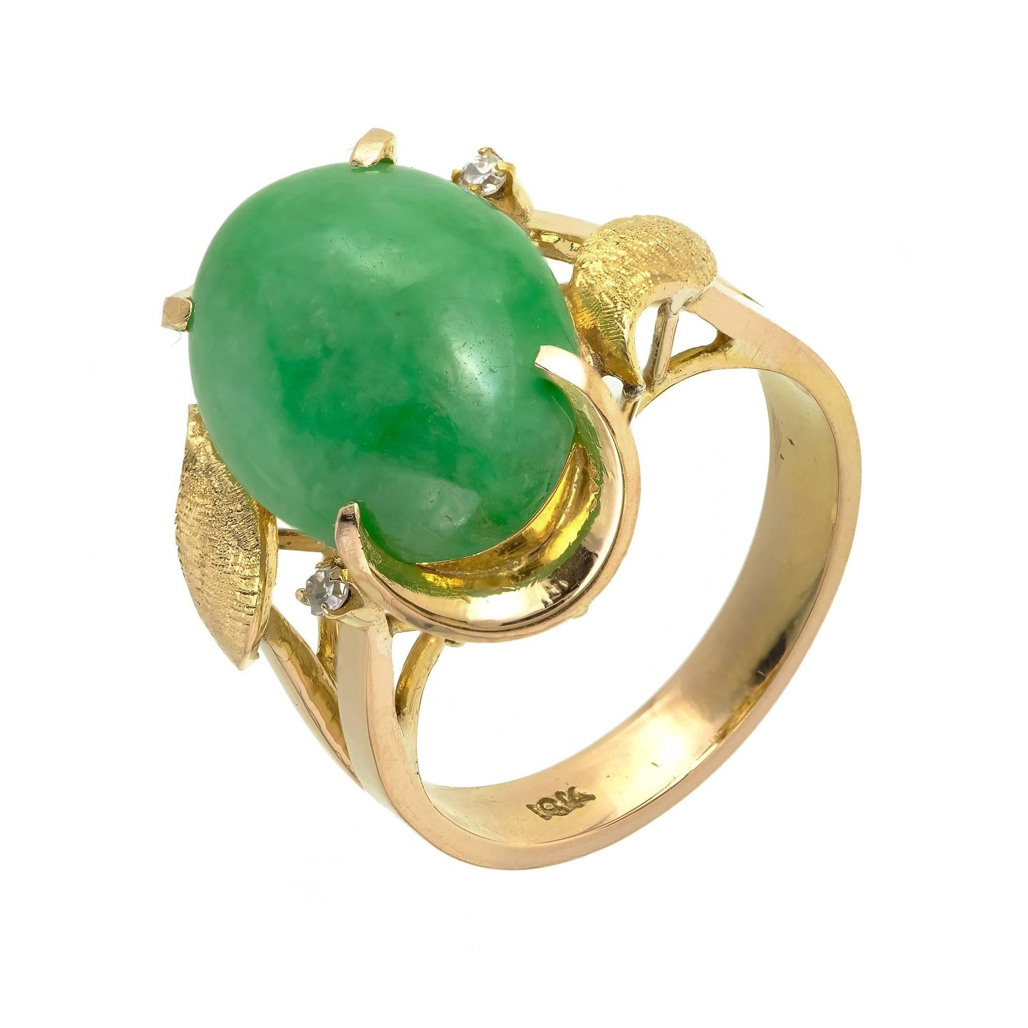 Natural Jadeite Jade mottled green ring in 18k yellow gold with shiny Diamond accents and hand textured gold leaves.

1 oval cabochon mottled green Jadeite Jade, 16.47 x 11.45 x 3.96mm, GIA certificate #2185636049
2 single cut Diamonds, approx.