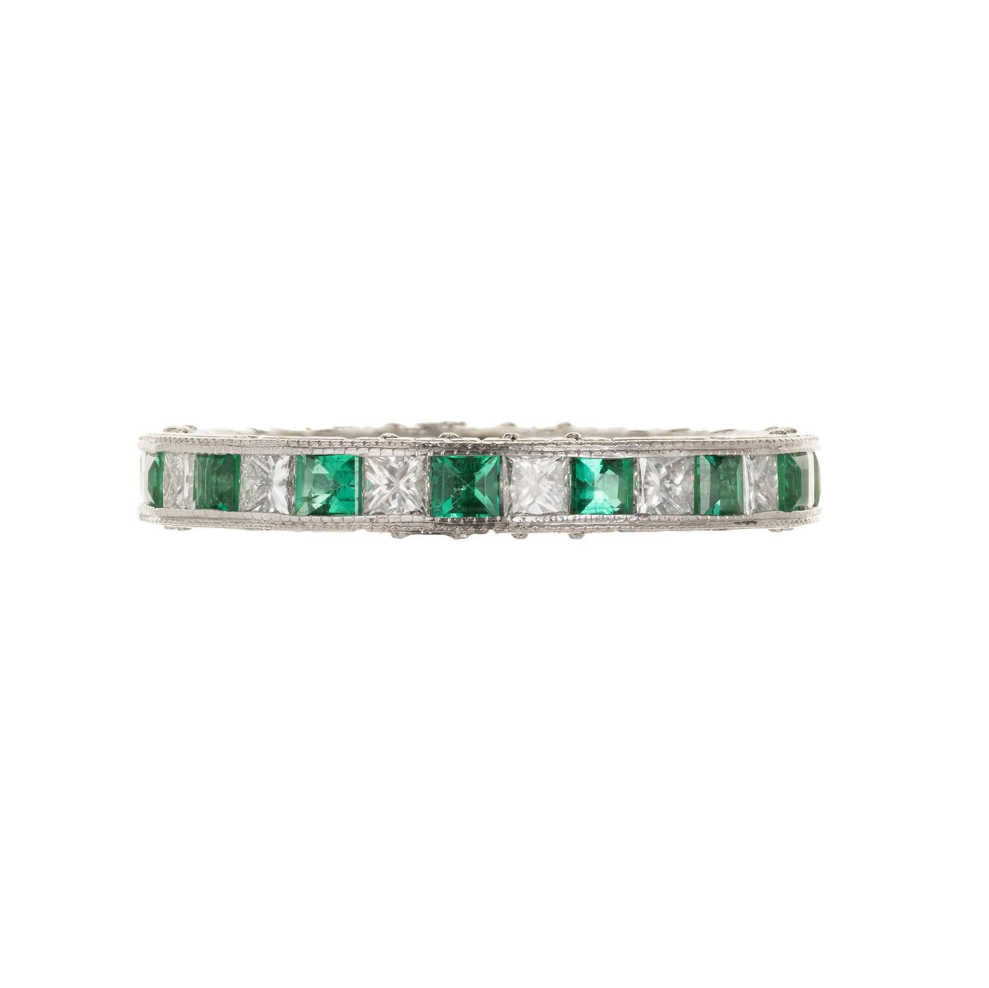 Princess cut Diamond and Emerald beaded channel set platinum wedding band from OGI with hand engraving along the setting.

15 Princess cut Diamonds, approx. total weight .85cts, F, VS
15 square cut bright green Emeralds, approx. total weight