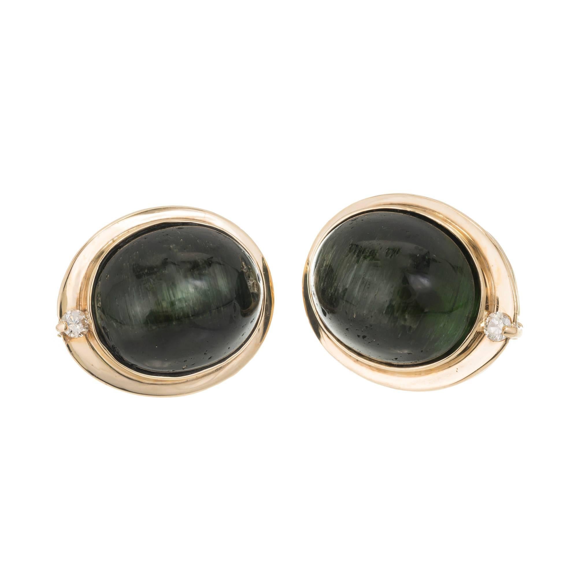 Natural untreated green cats eye Tourmaline 14k yellow gold diamond clip post earrings

Two full cut diamonds, approx. total weight .06cts, G, VS2. AGL certificate # CS49501AB
Two matched natural untreated no heat no enhancements 14 x 11mm dark