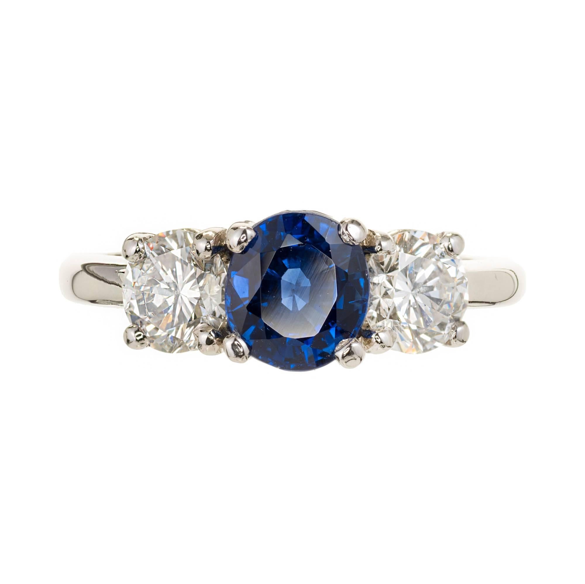 Classic three-stone ring with blue Sapphire center and 2 side diamonds. GIA certified Sapphire, fine Royal blue, simple heat only. Bright white well cut diamond sides. Peter Suchy Designs ring. 

950 Platinum
1 oval blue Sapphire, approx. total